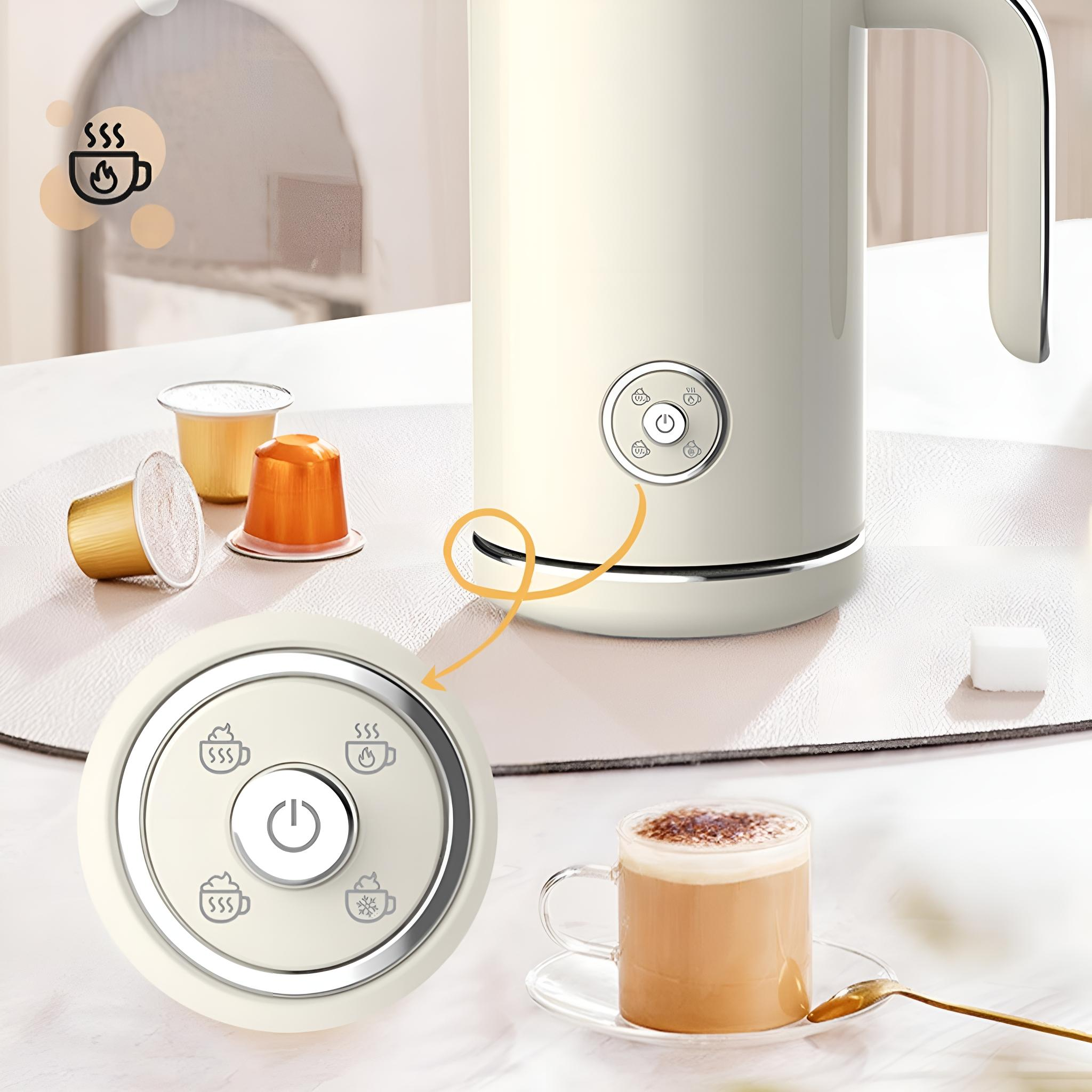 Cremefarbener Wasserkocher mit Knöpfen und eine Tasse Kaffee, mit Kaffeepads auf einem Tisch.
