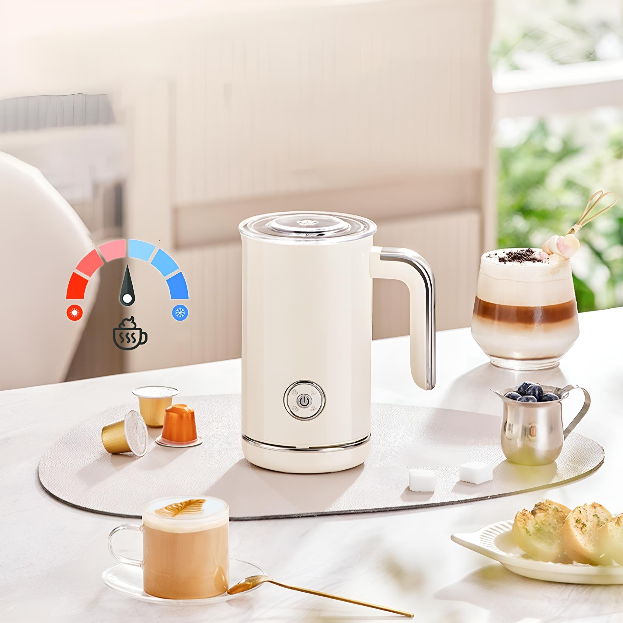 Ein weißer Milchaufschäumer mit Temperaturregler und eine Tasse Latte im Vordergrund. Andere Getränke sind ebenfalls vorhanden.