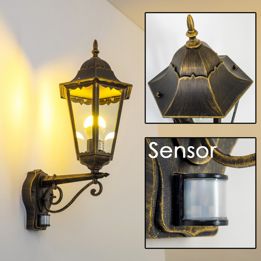 Außenwandleuchte mit Sensor, beleuchtet, an einer weißen Wand. Details der Lampe werden gezeigt.