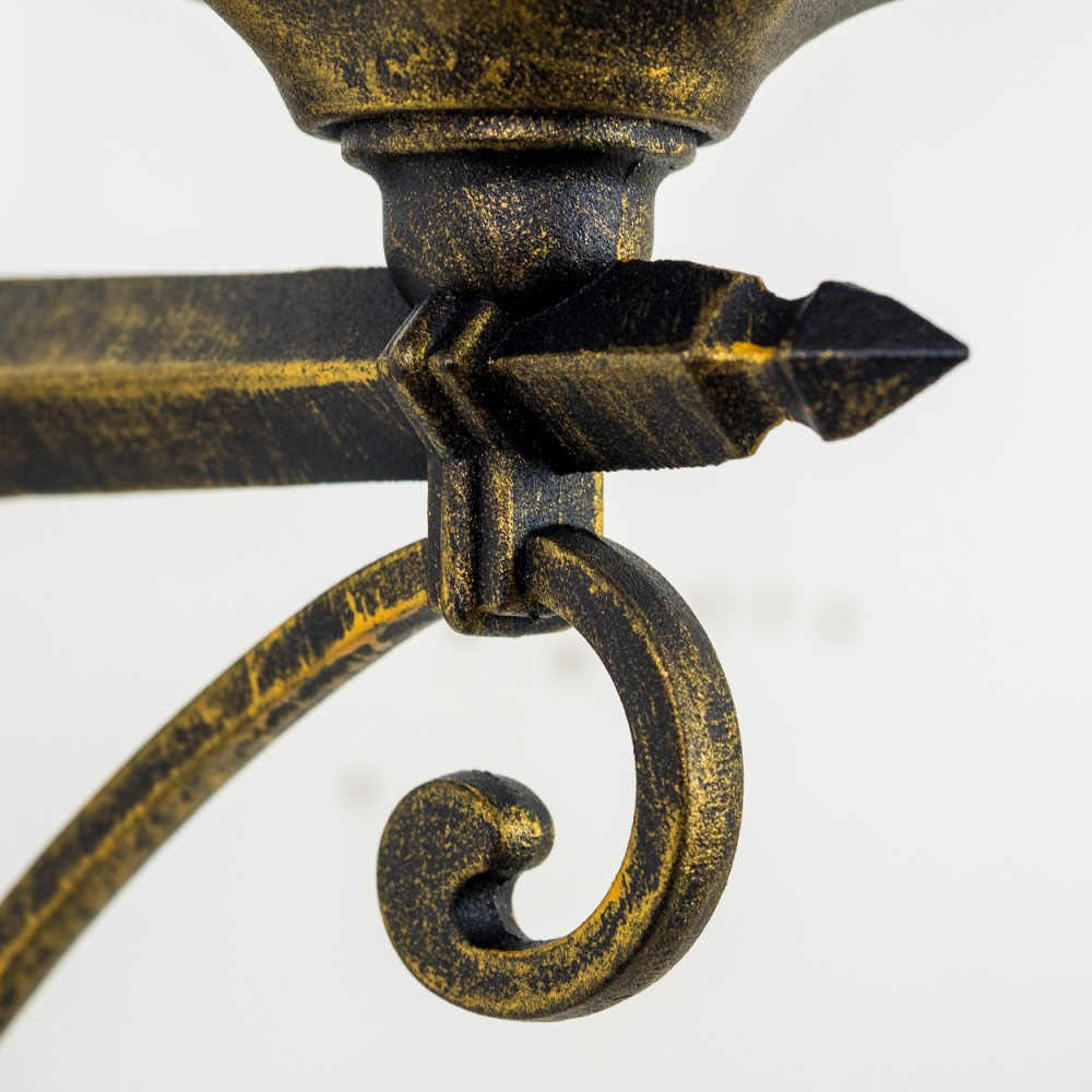 Detailaufnahme einer Außenwandleuchte mit Goldoberfläche und dekorativem Scroll-Detail.