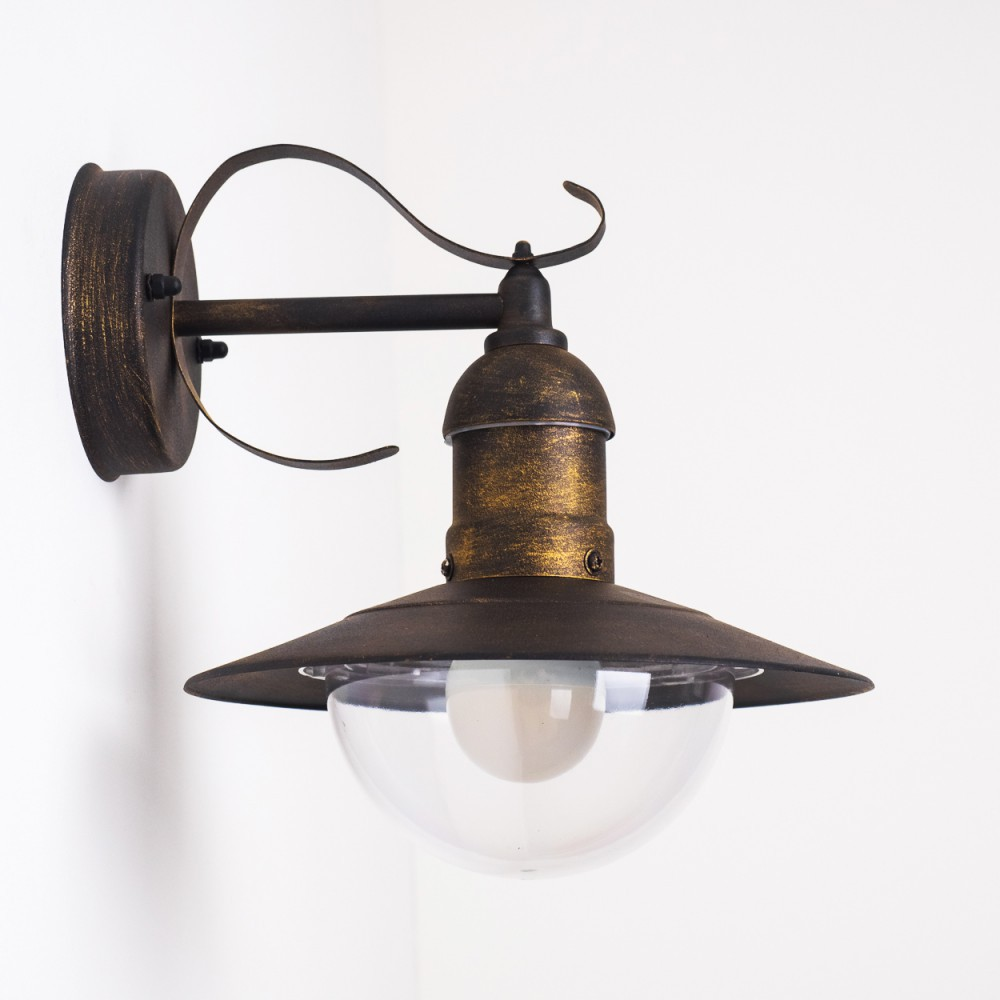 Verzierte bronzefarbene Wandlampe mit weißem Globus auf weißem Hintergrund. Die Lampe hat eine geschwungene Oberseite.
