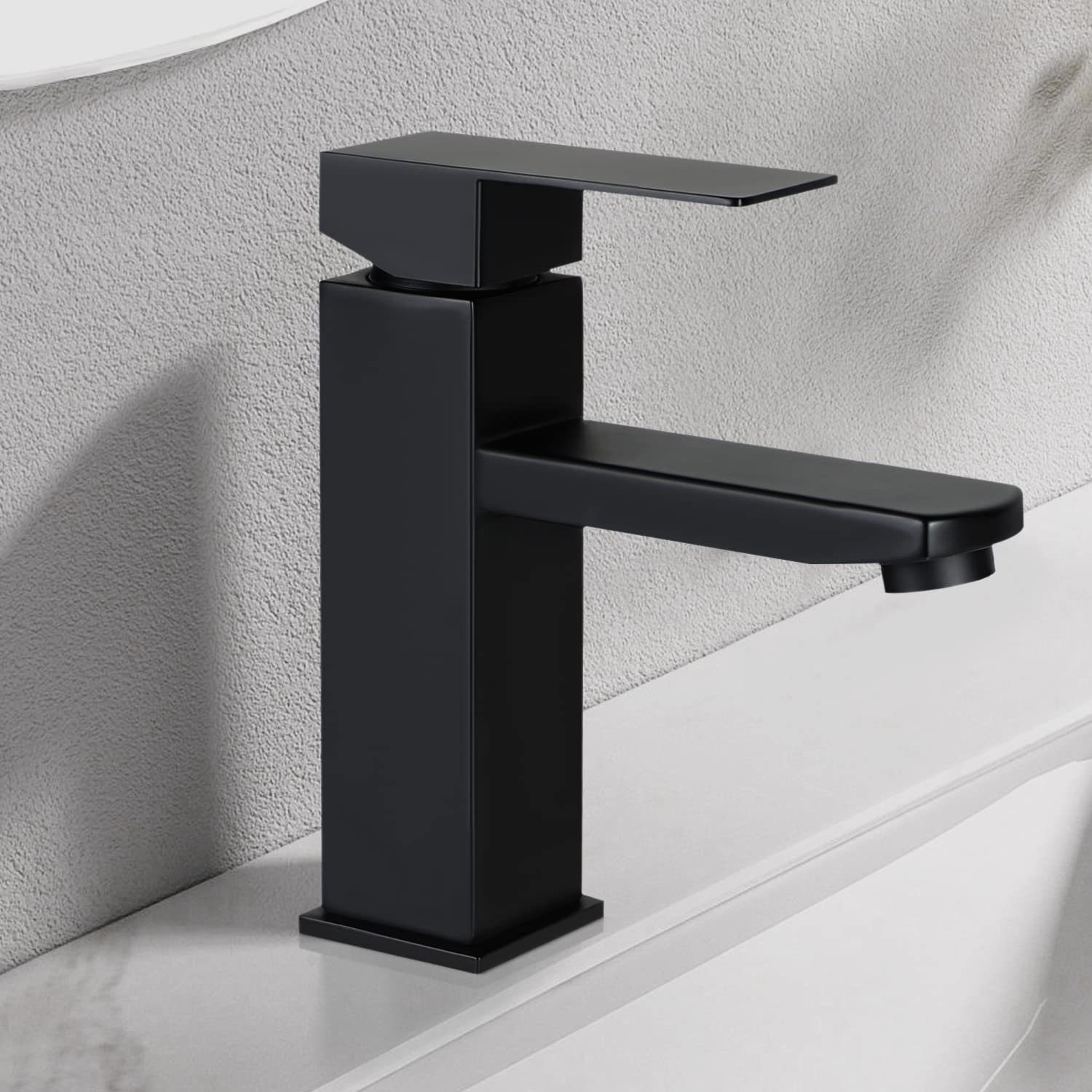 Ein schwarzer Wasserhahn mit einfachem Design. Er steht auf einer weißen Oberfläche, mit Schatten.