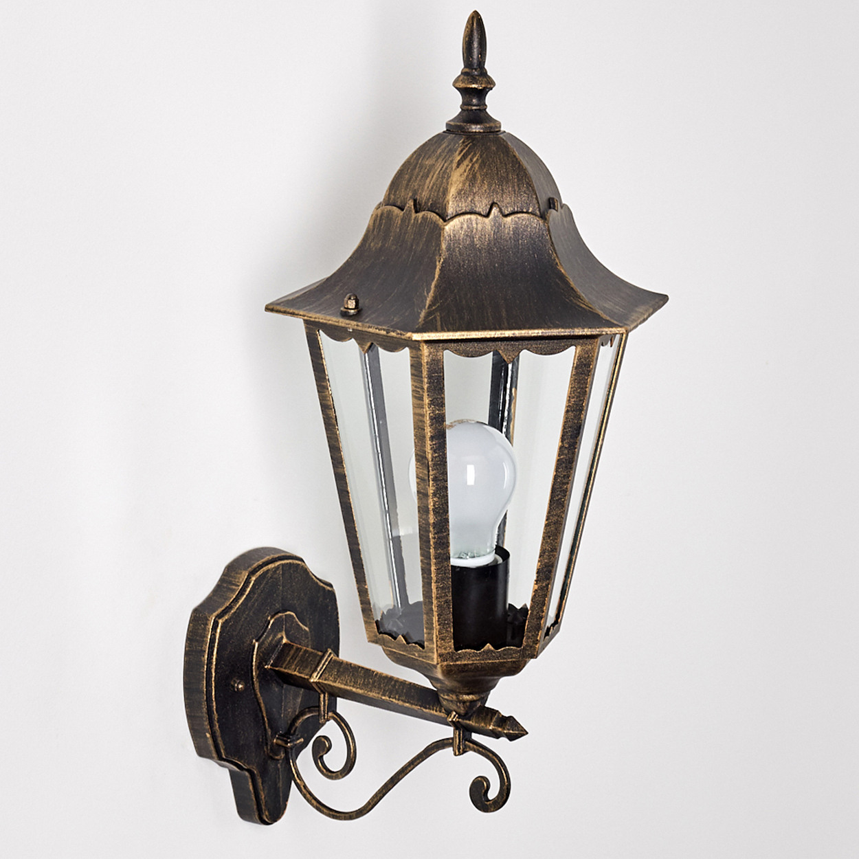 Wandmontierte, verzierte Außenlampe mit Glasgehäuse und Maßen, Bronze und Gold, weißer Hintergrund.