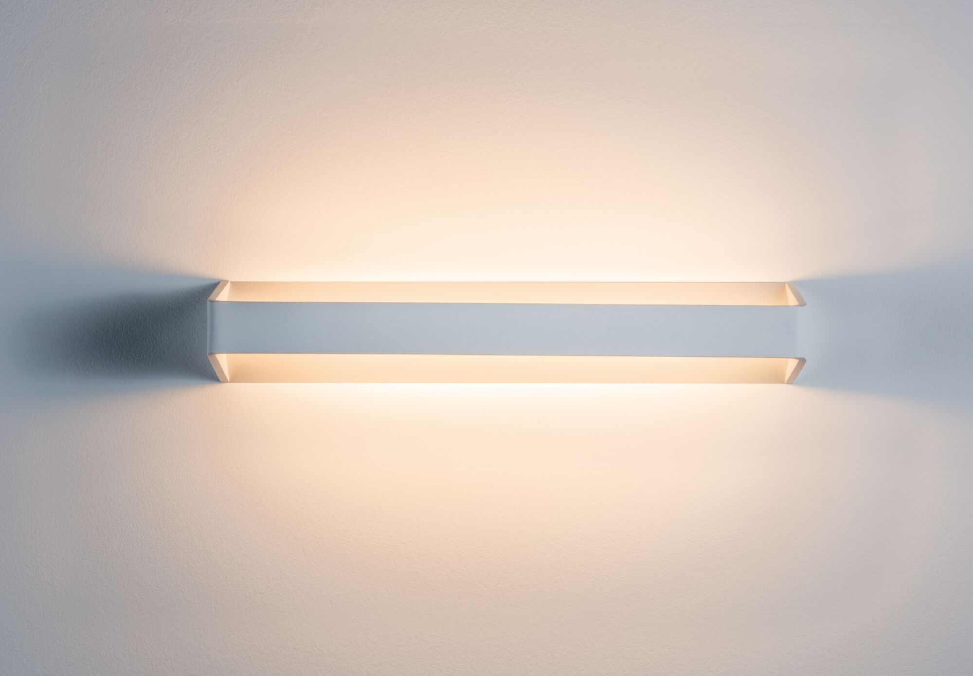Ein weißes rechteckiges Licht mit orangefarbenen Clips und Drähten.