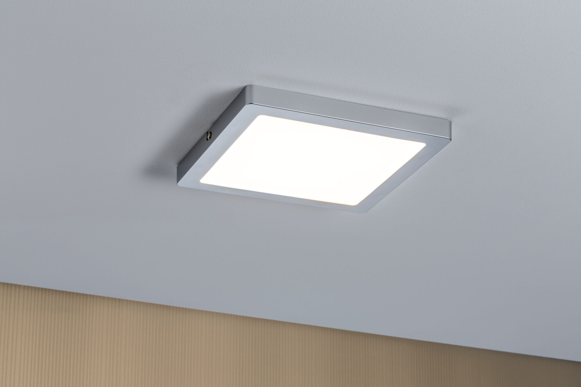 Quadratische, silberne LED-Deckenleuchte. Das Licht ist an und strahlt hellweiß.