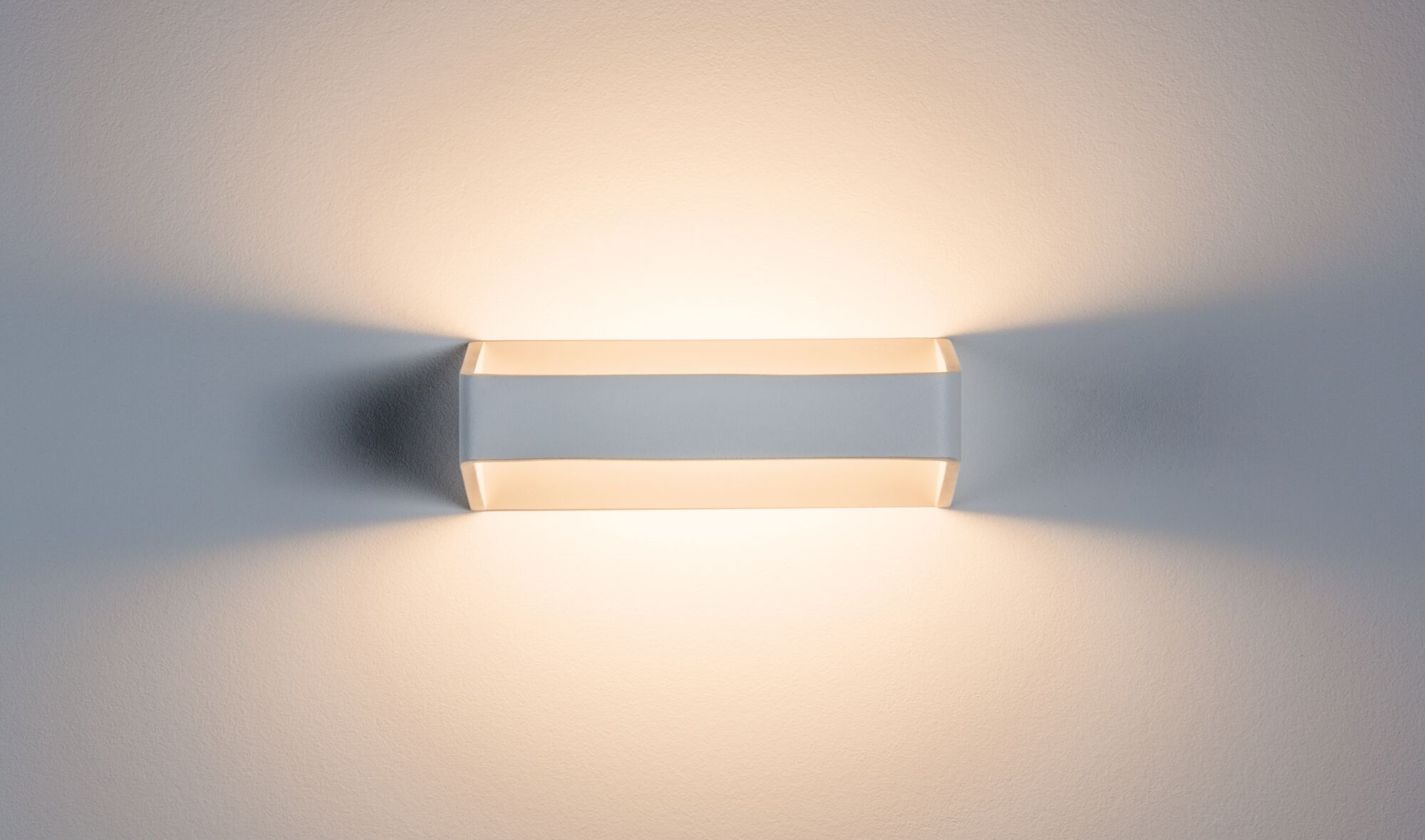 Eine weiße, an der Wand montierte Leuchte, die Licht aussendet.