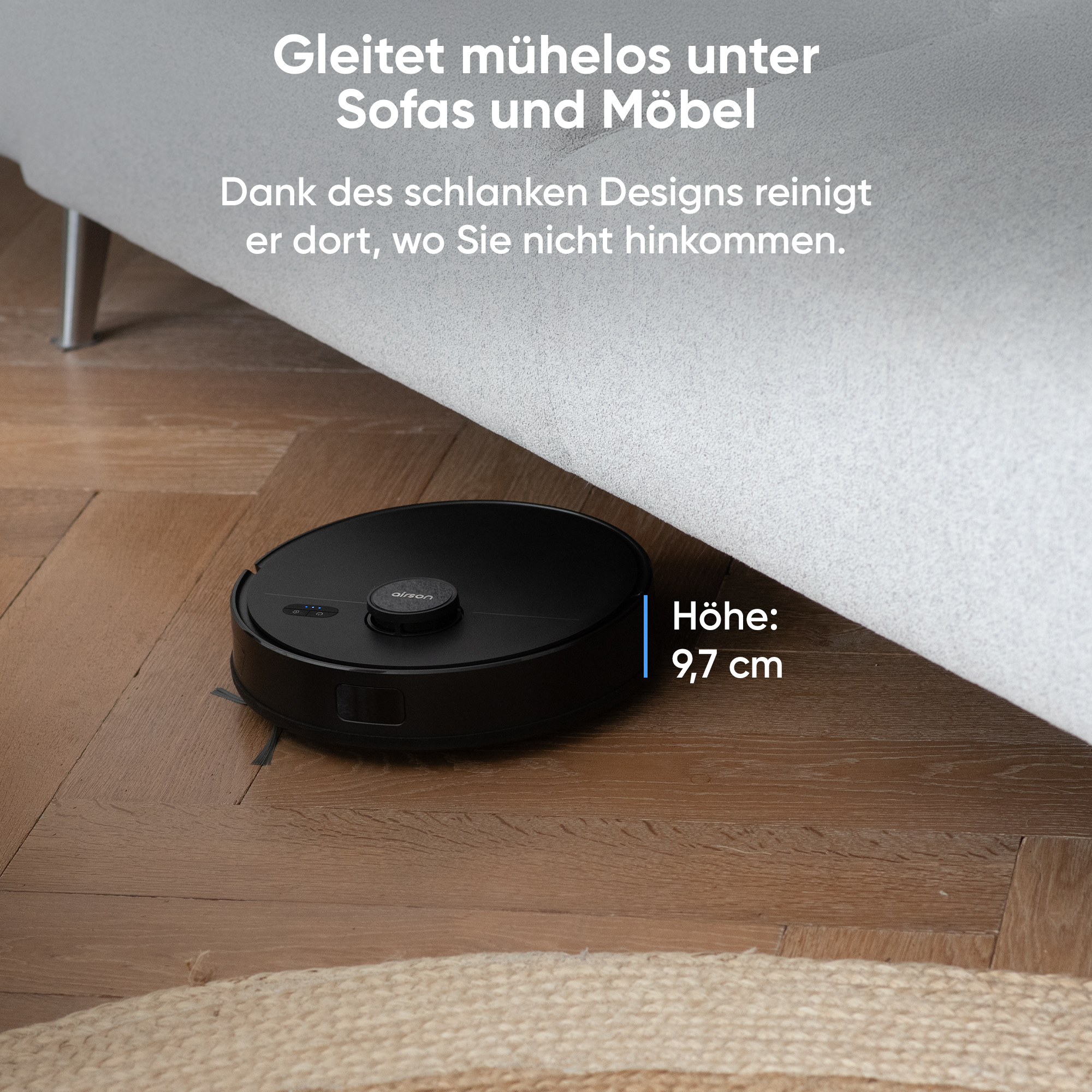 Ein Roboter-Staubsauger reinigt einen Holzboden unter einem Sofa. Der Staubsauger ist schwarz. Die Höhe beträgt 9,7 cm.