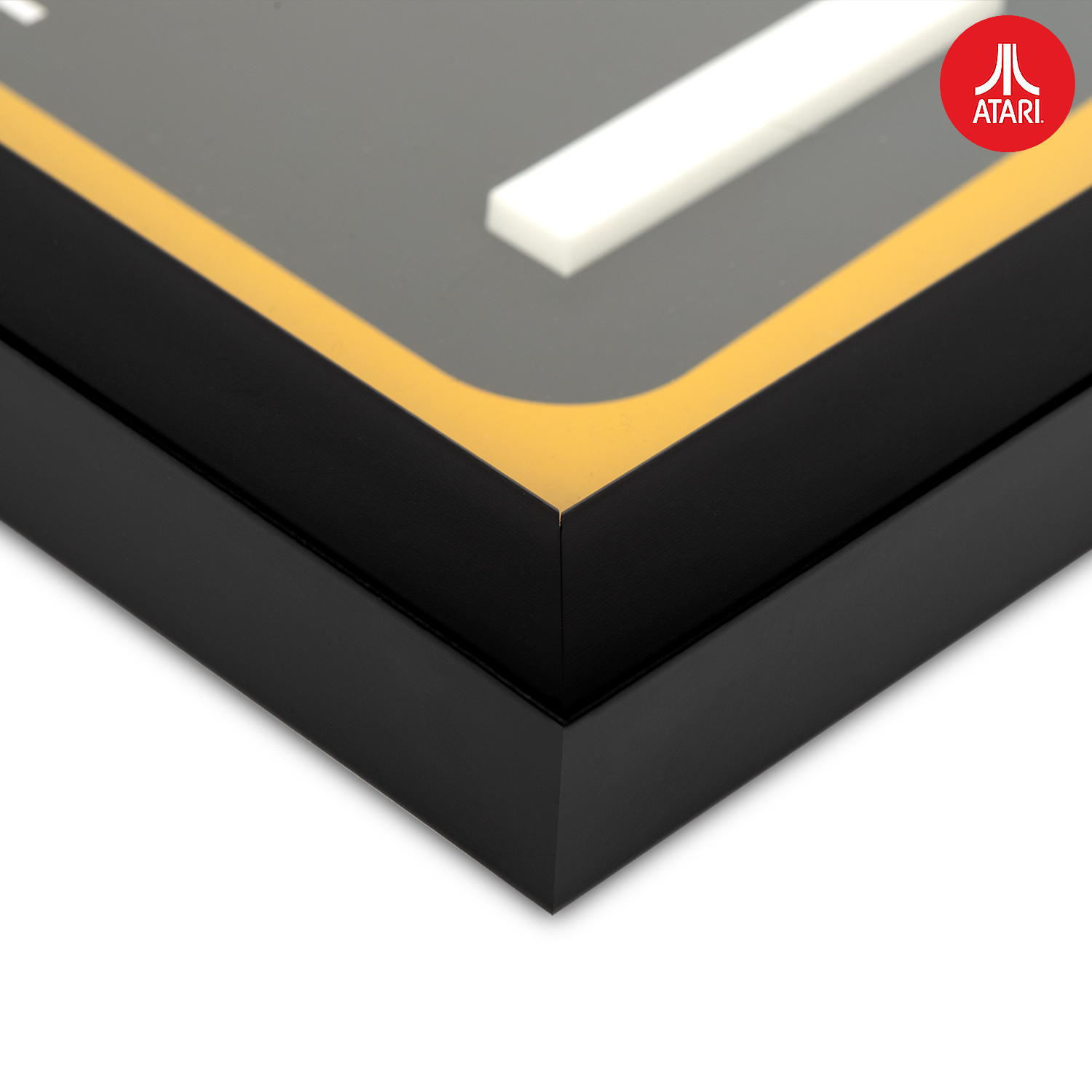 Close-up van een ingelijste Atari-logoklok met een zwart frame en een gouden rand.