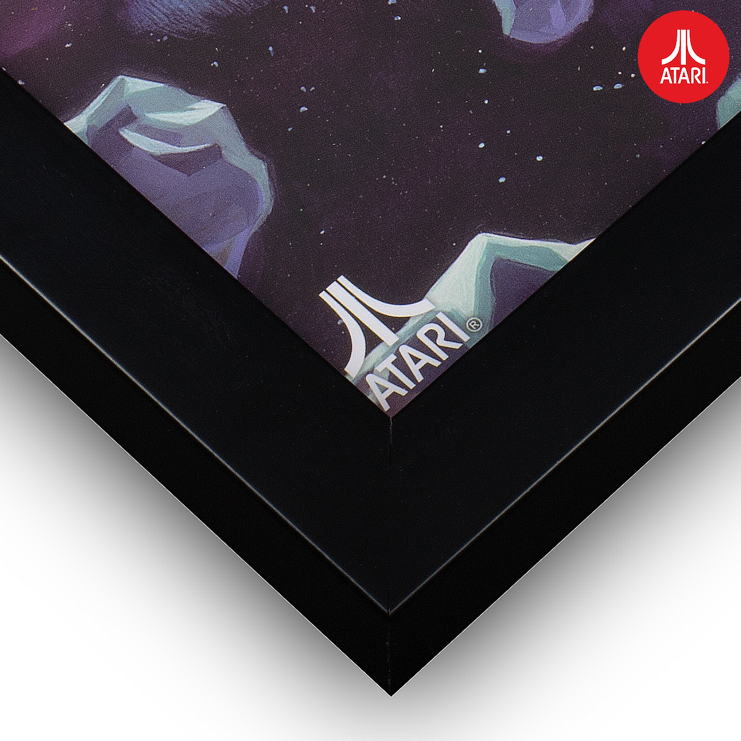 Close-up van een ingelijkte Atari-afdruk met hoekweergave. Zwart frame. Atari-logo in de hoek.