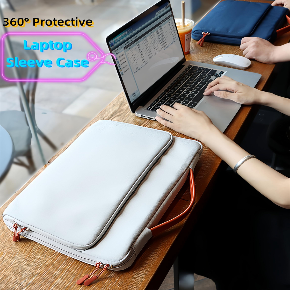 Ein Laptop und eine hellgraue Laptoptasche auf einem Holztisch. Person benutzt den Laptop, mit orangefarbenen Reißverschlussdetails.