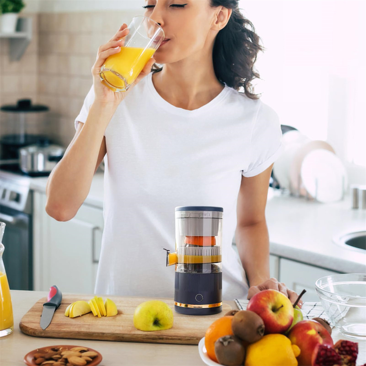 Eine Frau trinkt Saft aus einem Glas. Es gibt einen Entsafter, geschnittenes Obst und ein Holzbrett mit einem Messer.