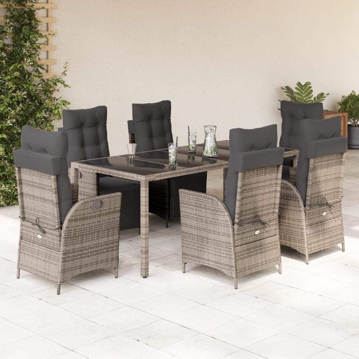 Ein Esszimmer-Set mit Tisch und Stühlen auf einer Terrasse. Die Stühle haben graue Kissen.