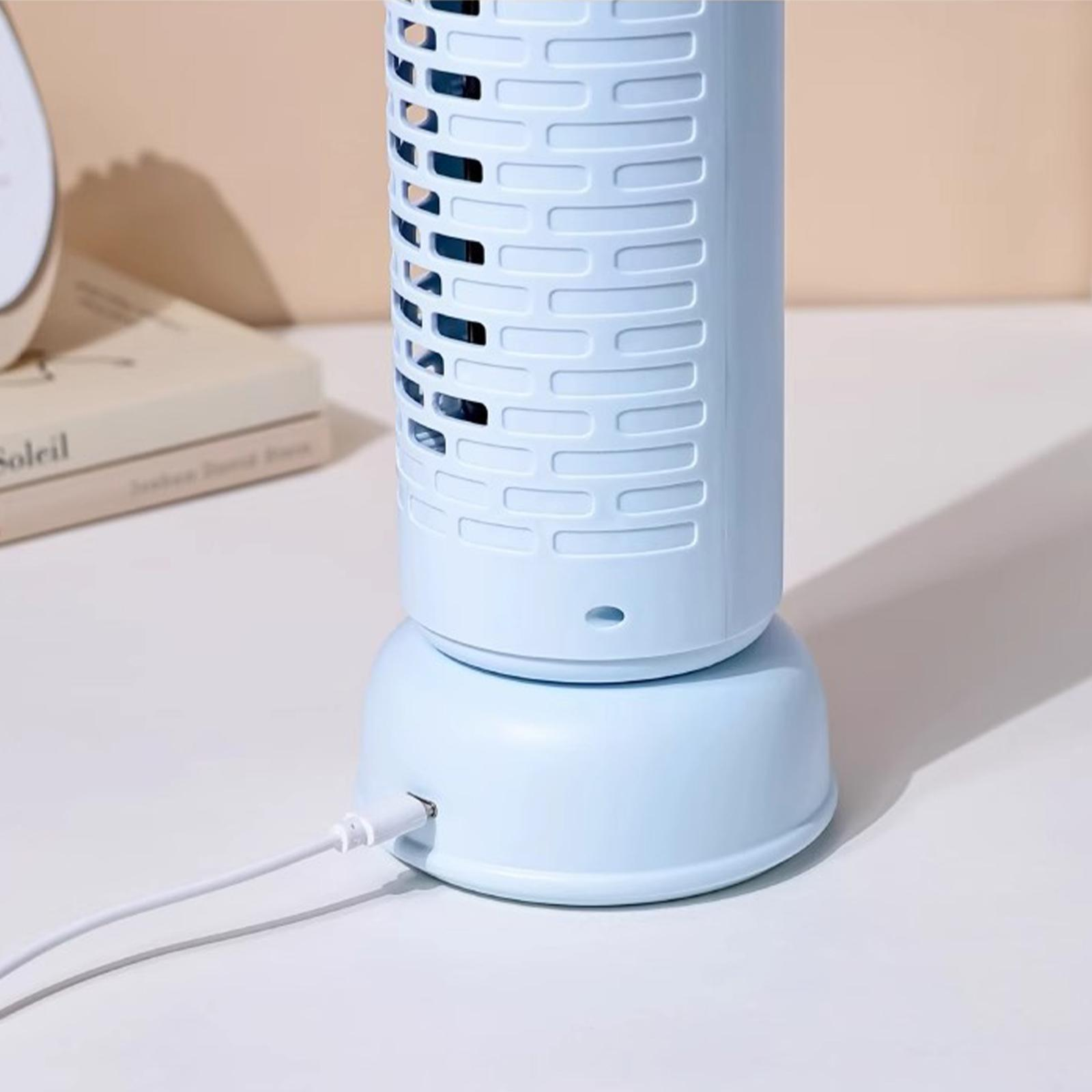 Hellblauer kleiner Ventilator, USB-Kabel angeschlossen. Buch dahinter.