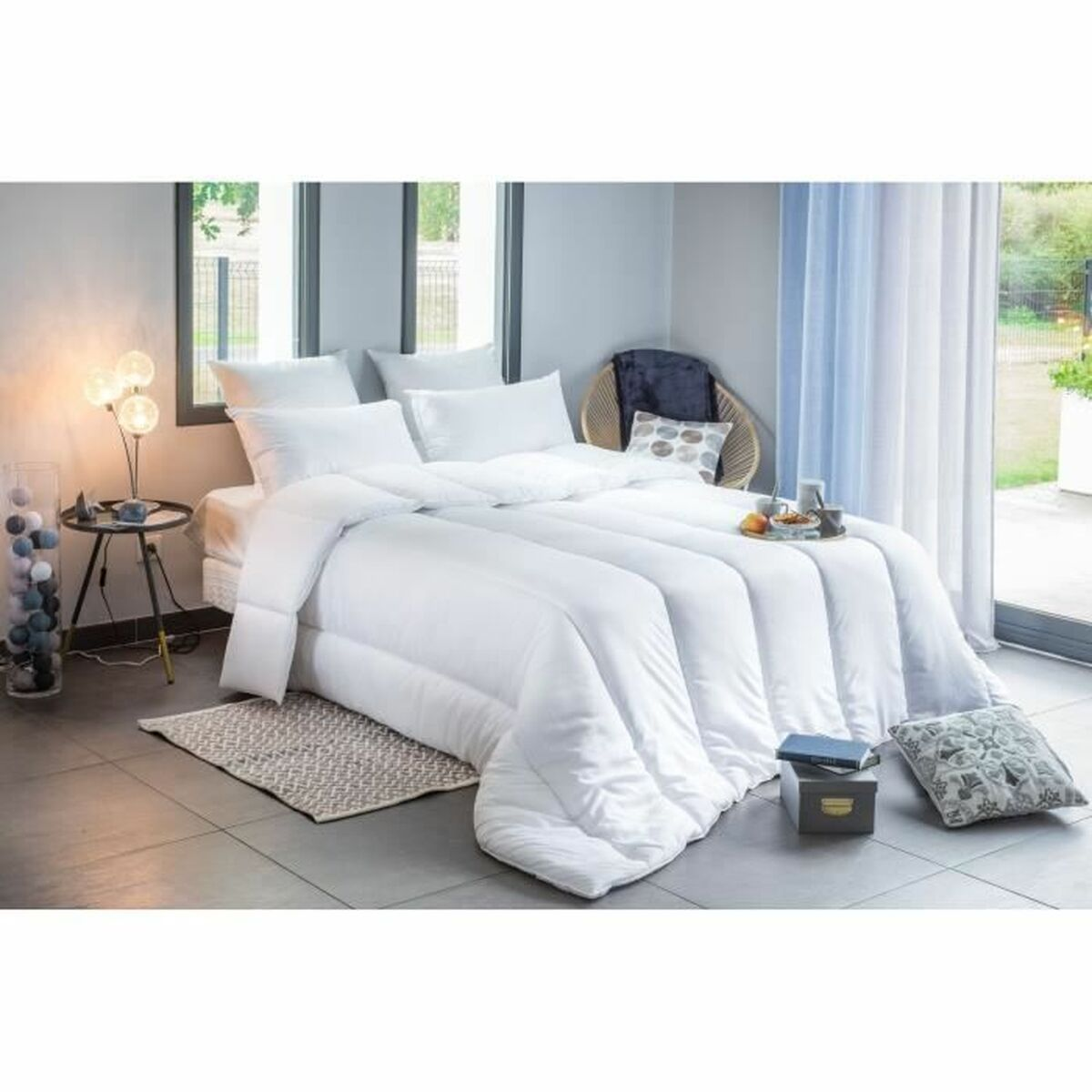 Ein Bett mit weißer Bettwäsche und Kissen in einem hellen Raum.