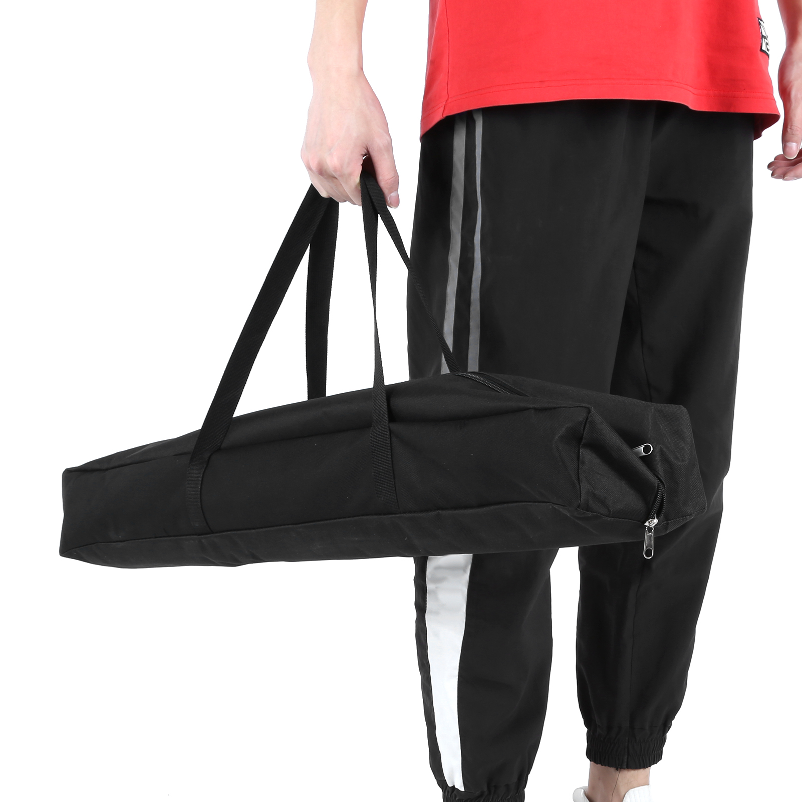 Eine Person hält eine schwarze Tasche mit Griffen. Die Tasche ist lang und rechteckig.