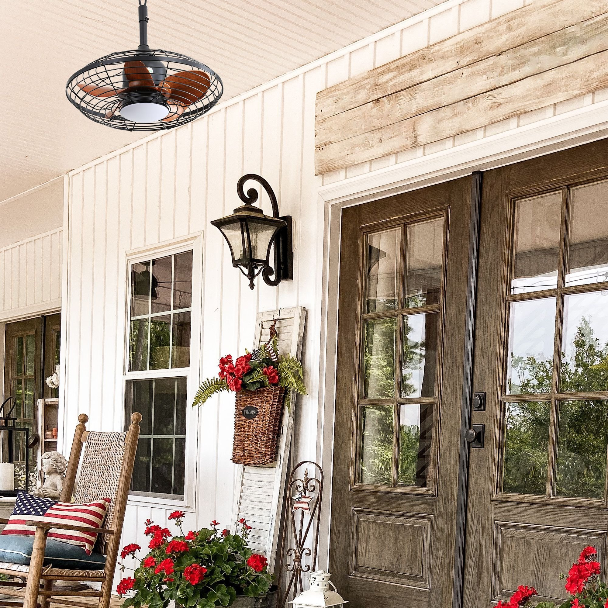 Eine Veranda mit Ventilator, Stühlen, Blumen und einer Holztür mit Fenstern.
