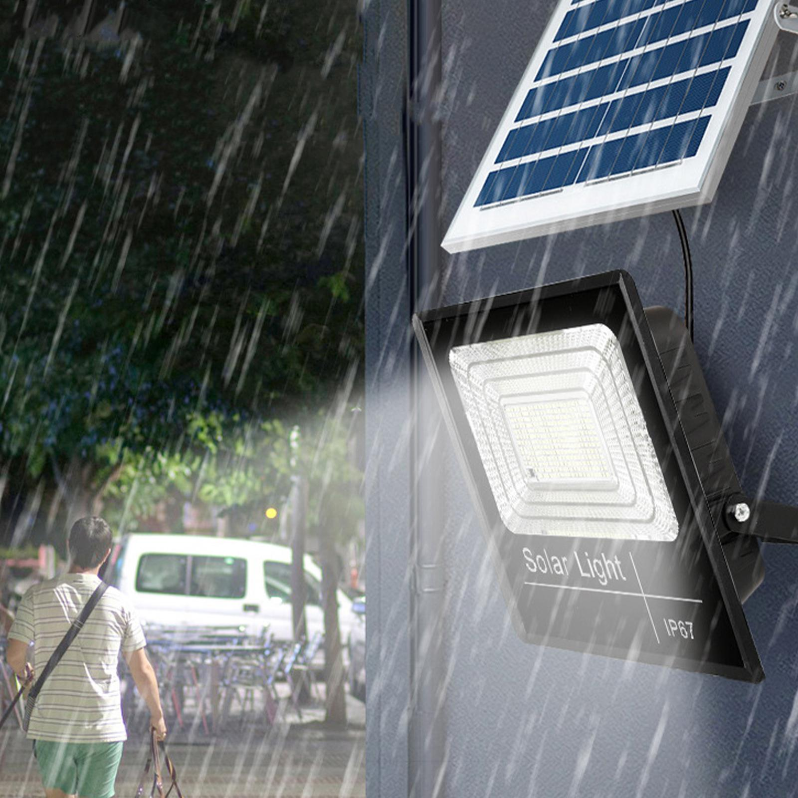 Solarleuchte mit Solarpanel im Regen. Im Hintergrund geht eine Person.