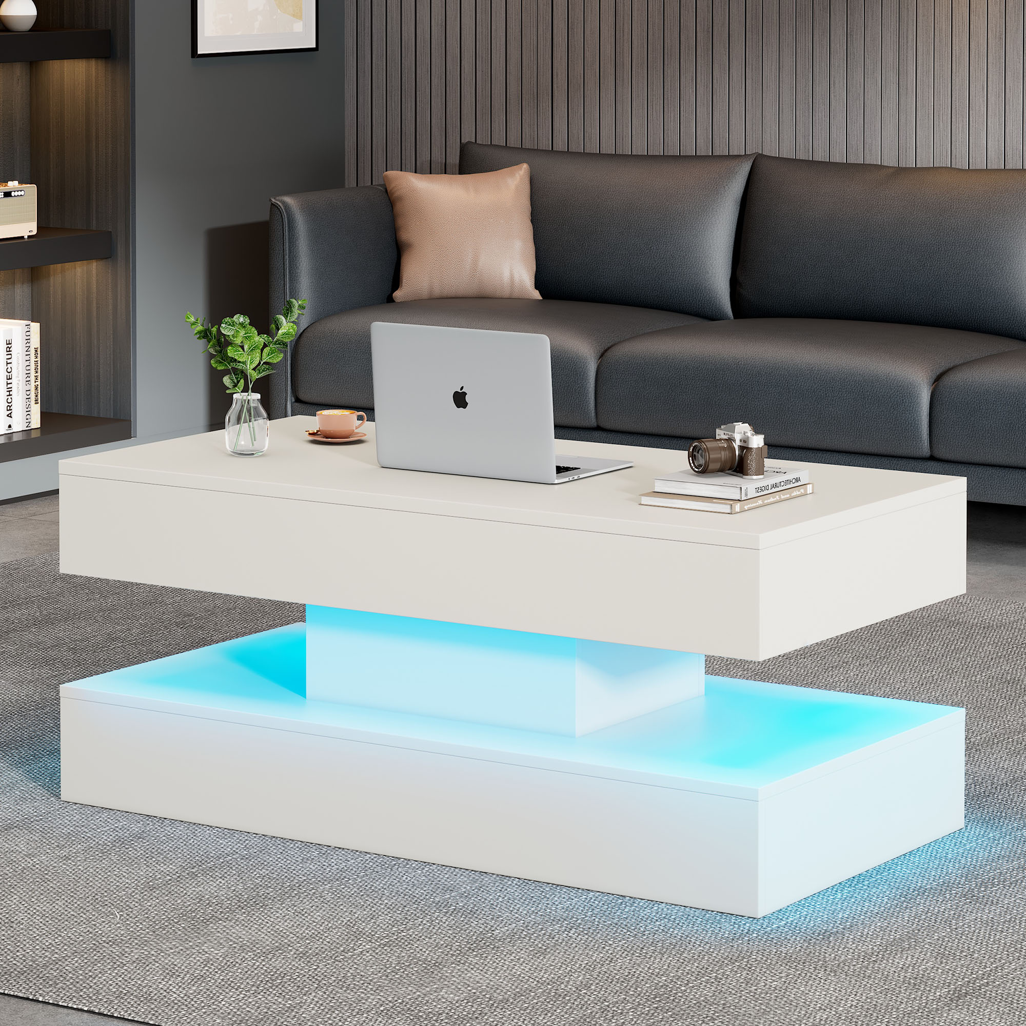 Weißer, moderner Couchtisch mit blauer LED-Beleuchtung. Laptop, Kaffeetasse und Dekorationen sind oben.