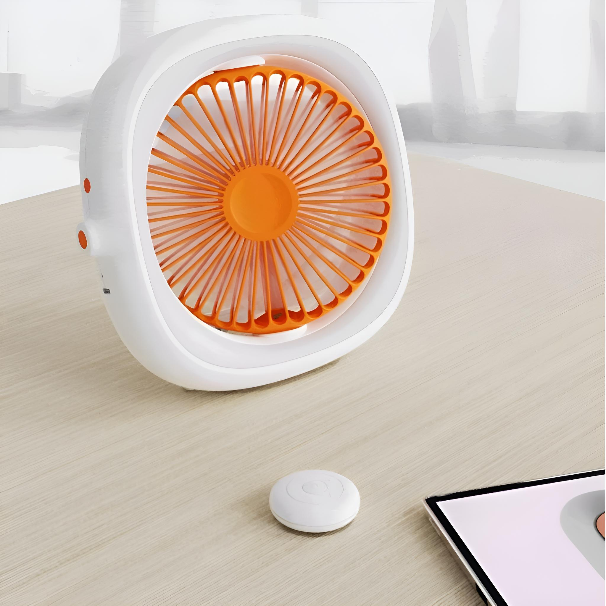 Kleiner weißer Ventilator mit orangefarbenen Flügeln. Ein weißer Knopf auf dem Tisch.
