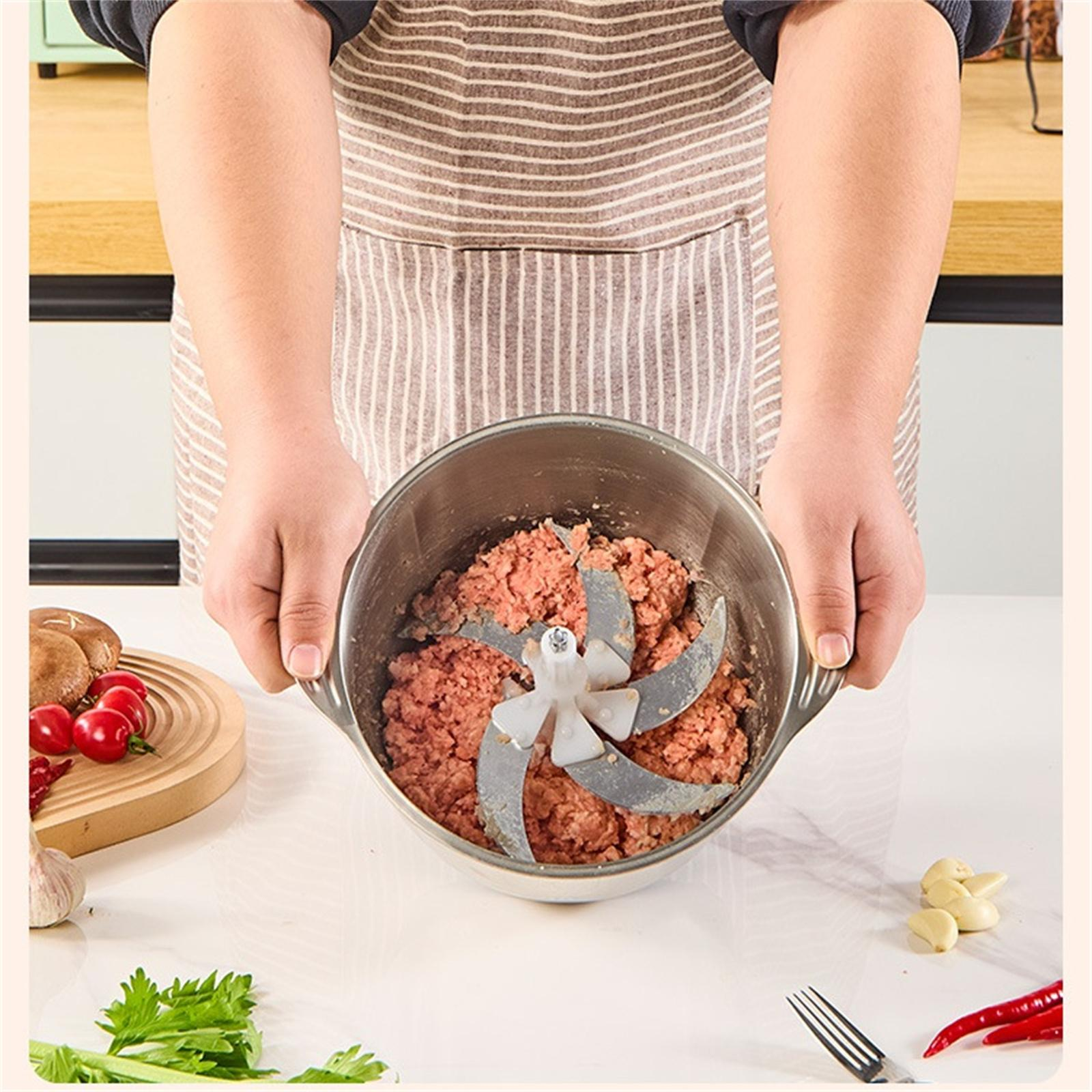 Eine Person hält eine Metallschüssel mit Hackfleisch und einer Klinge, zusammen mit Küchenzutaten.