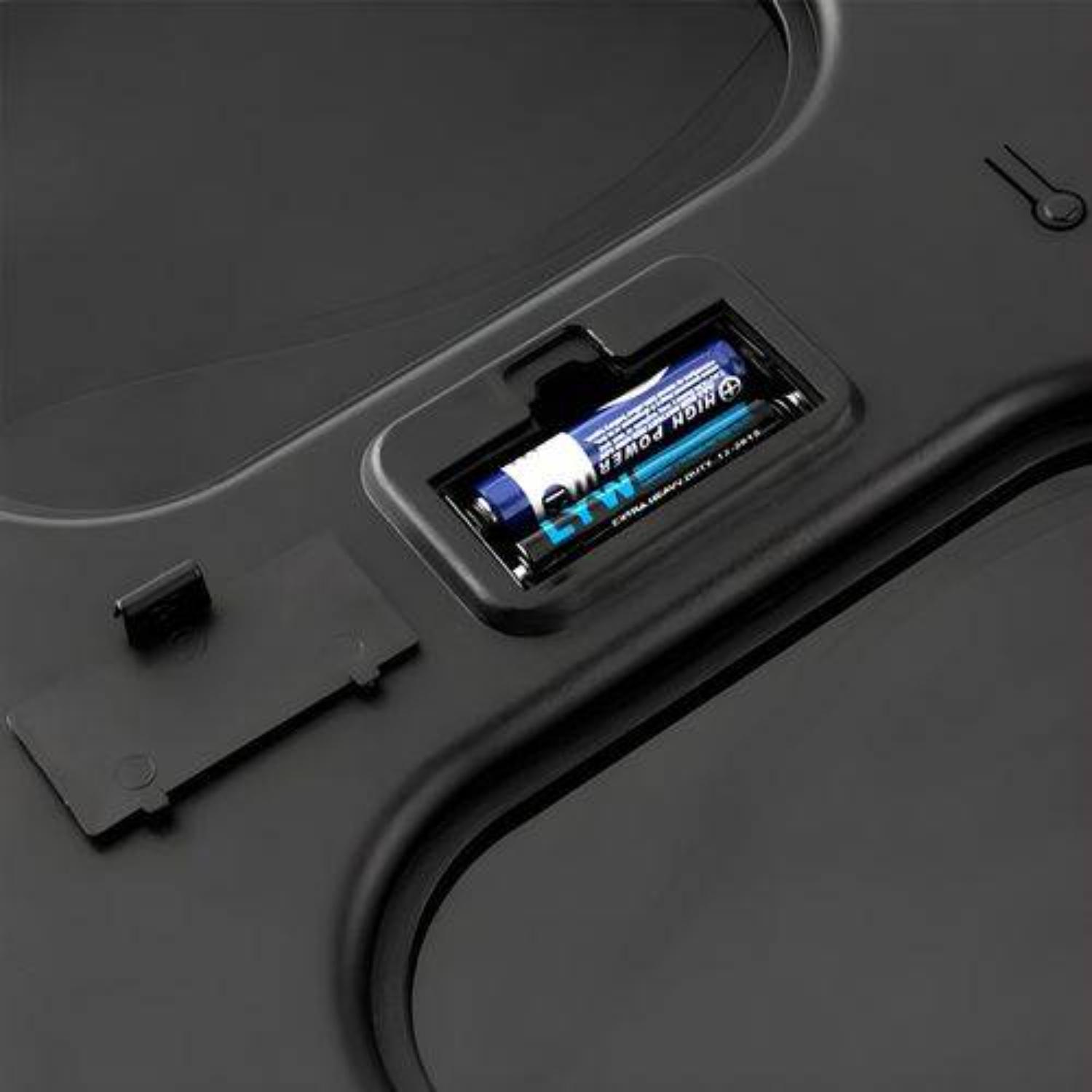 Schwarzes Objekt mit zwei AA-Batterien in einem Fach. Deckel ist geöffnet. Schwarzer Hintergrund.
