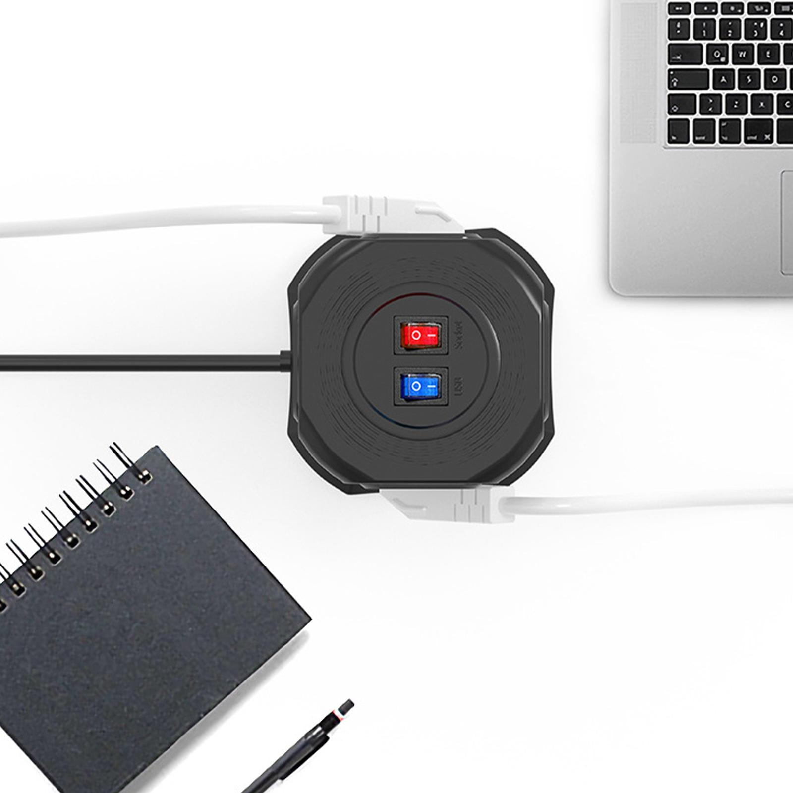 Eine schwarze Steckdosenleiste mit zwei Schaltern, verbunden mit einem Laptop, Stift und Notizbuch.