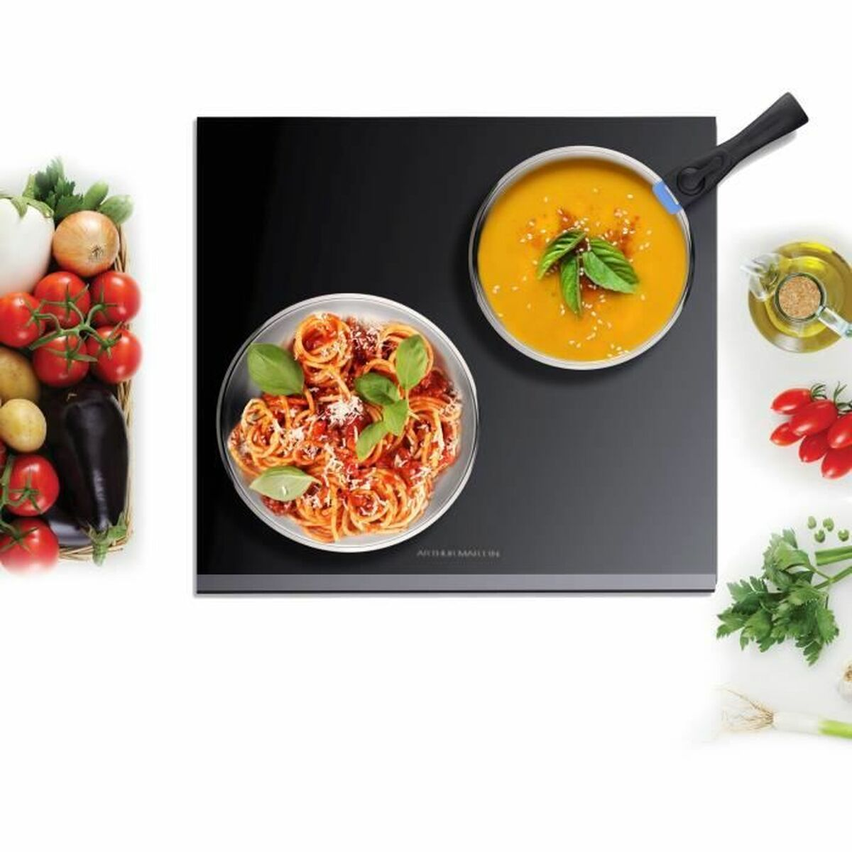 Ein Tisch mit Gerichten: Pasta mit Sauce, Suppe in einer Pfanne, Gemüse und Zutaten, alles ordentlich angeordnet.