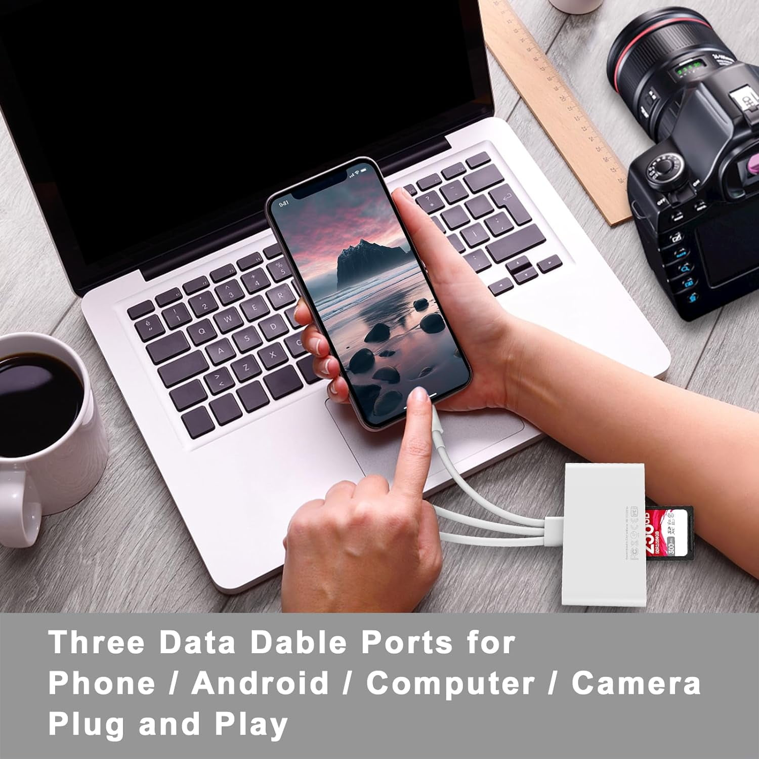 Ein Telefon, das an einen Hub mit Datenanschlüssen angeschlossen ist, in der Nähe eines Laptops, einer Kamera und einer Tasse.