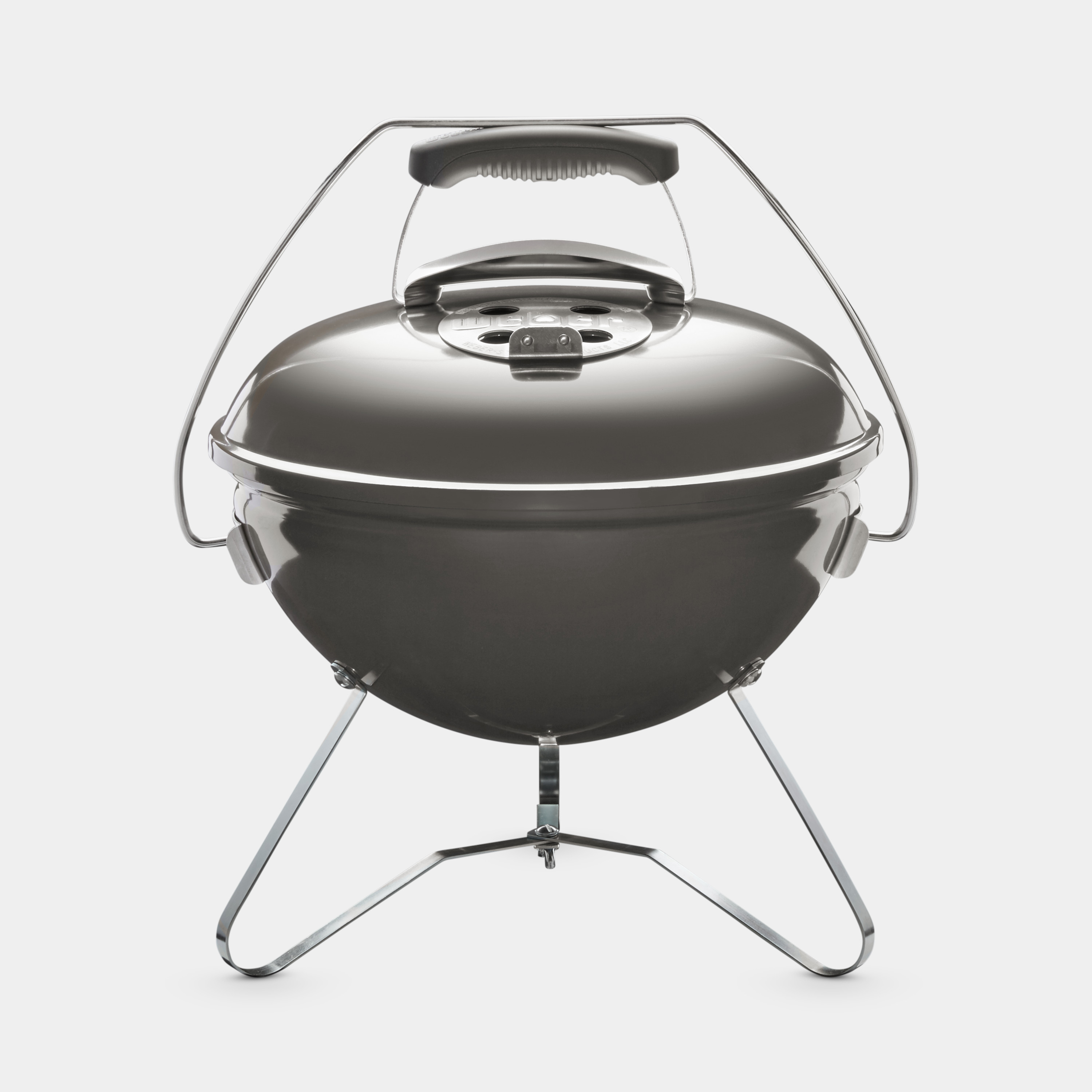 Szary, okrągły grill węglowy z pokrywą, uchwytem i nogami, na białym tle.