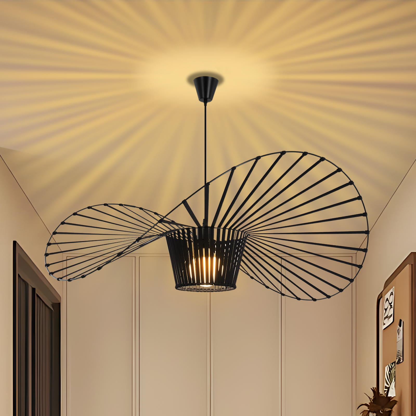Una lampada a sospensione nera a forma di ventaglio sul soffitto, che illumina la stanza. La stanza ha porte e pareti neutre.