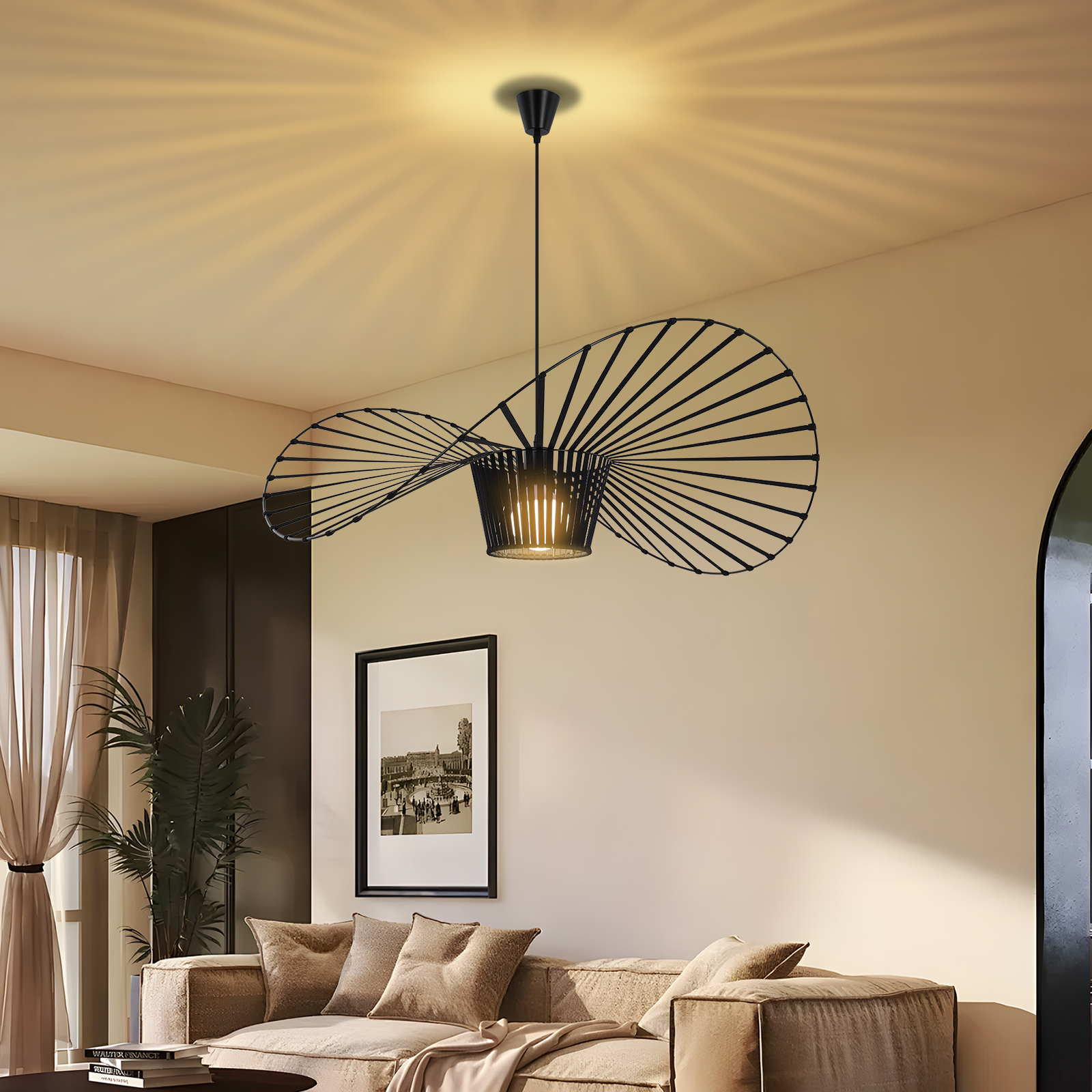 Un lampadario moderno con un design unico appeso in una stanza con un divano beige e un dipinto.