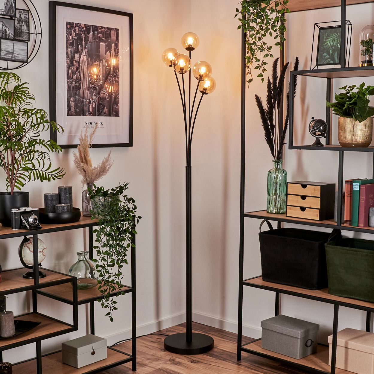 Stehlampe mit fünf Glaskugelleuchten, schwarzem Stiel und rundem Sockel.