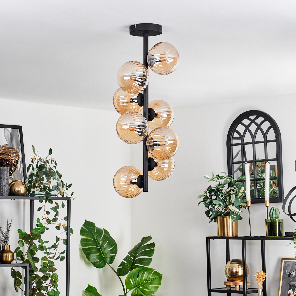 Deckenlampe mit acht Glaskugelleuchten an einem schwarzen Stiel, weißer Hintergrund.