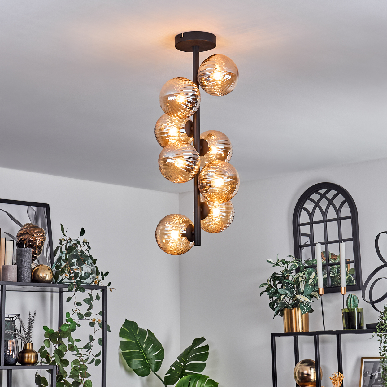 Ein Kronleuchter mit mehreren Glaskugeln, in einem Wohnzimmer.