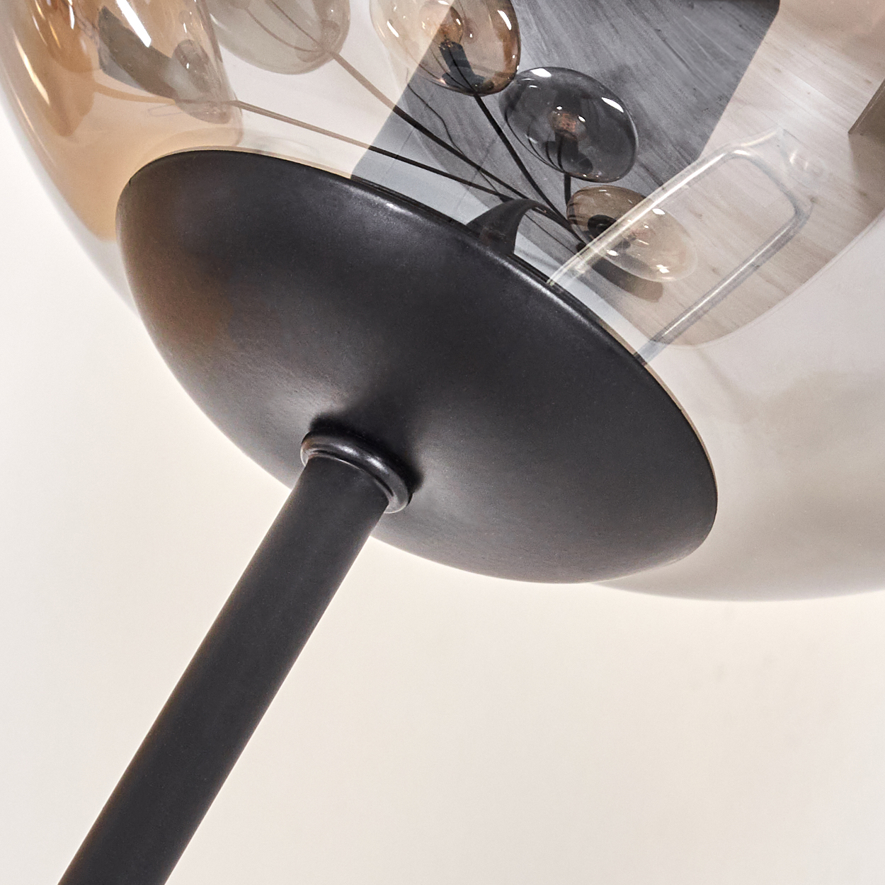Nahaufnahme einer schwarzen Stehlampe mit Glaskugeln. Die Lampe hat einen schwarzen Stiel und Sockel.