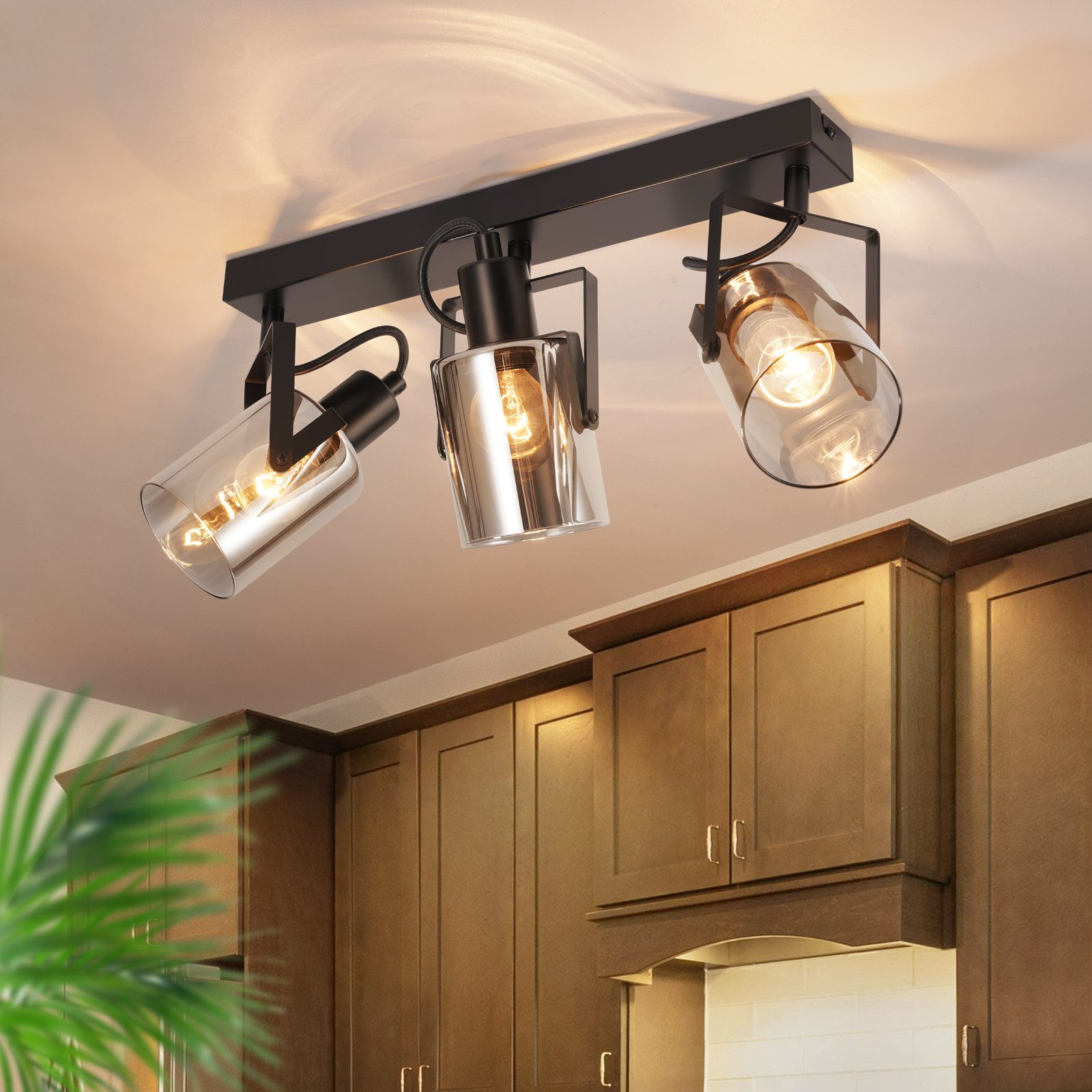 Lampada a tre luci sul soffitto. Sotto, armadi marroni.