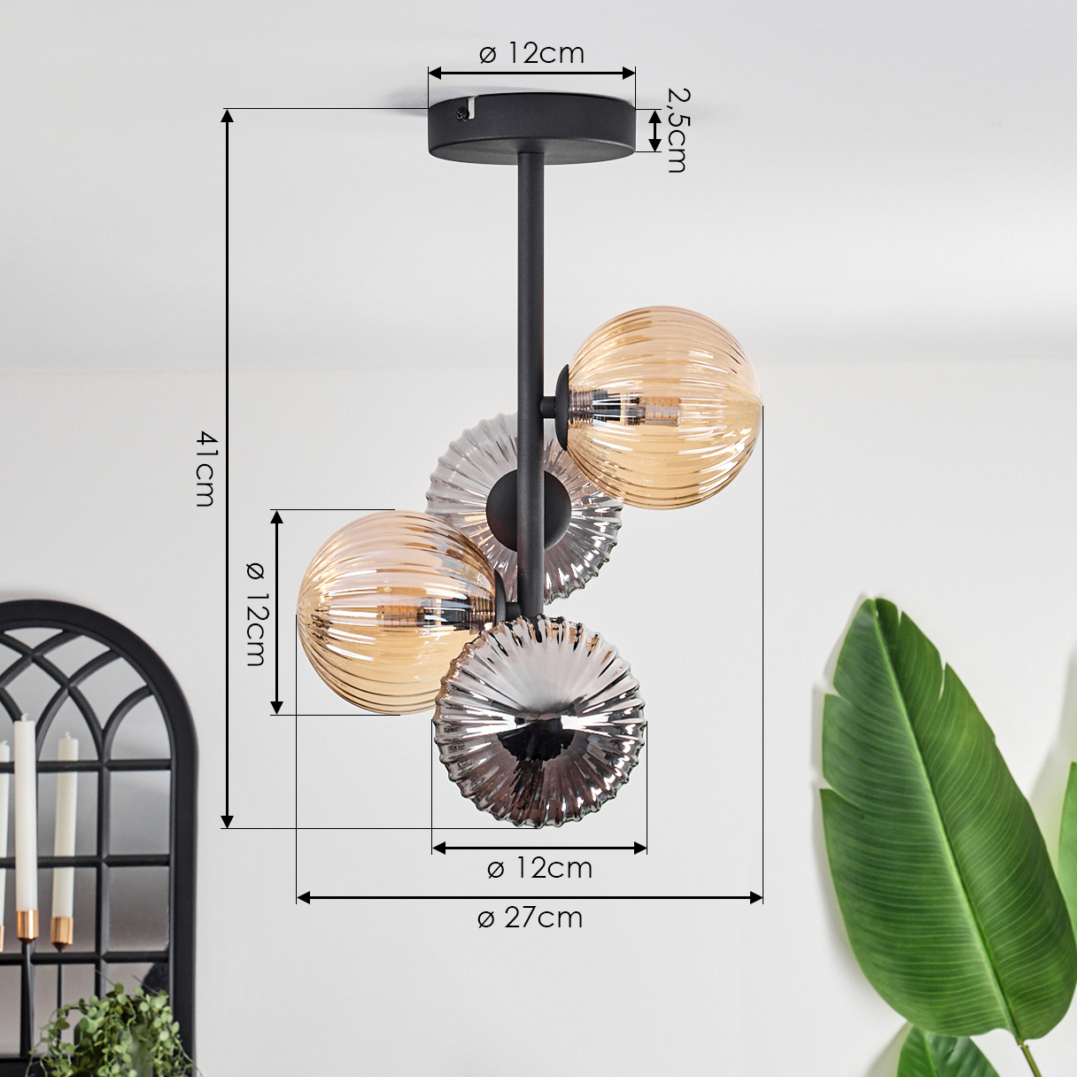 Eine schwarze Deckenlampe mit drei bernsteinfarbenen und silbernen Glaskugeln, Abmessungen werden angezeigt. Der Hintergrund ist weiß.