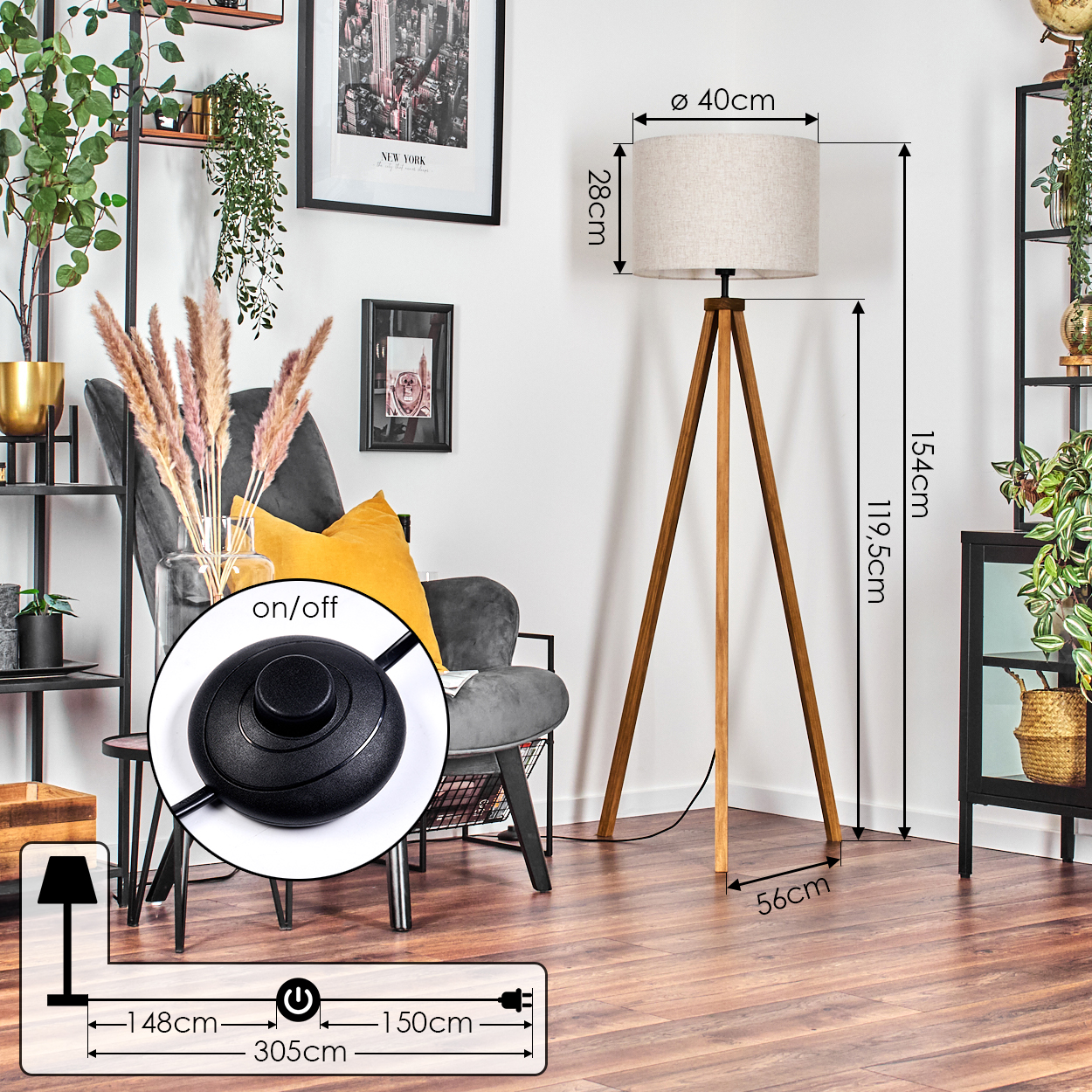 Holz-Stativ-Stehlampe mit beigem zylindrischen Schirm. Der Ein-/Ausschalter und der Stecker sind im Vordergrund.