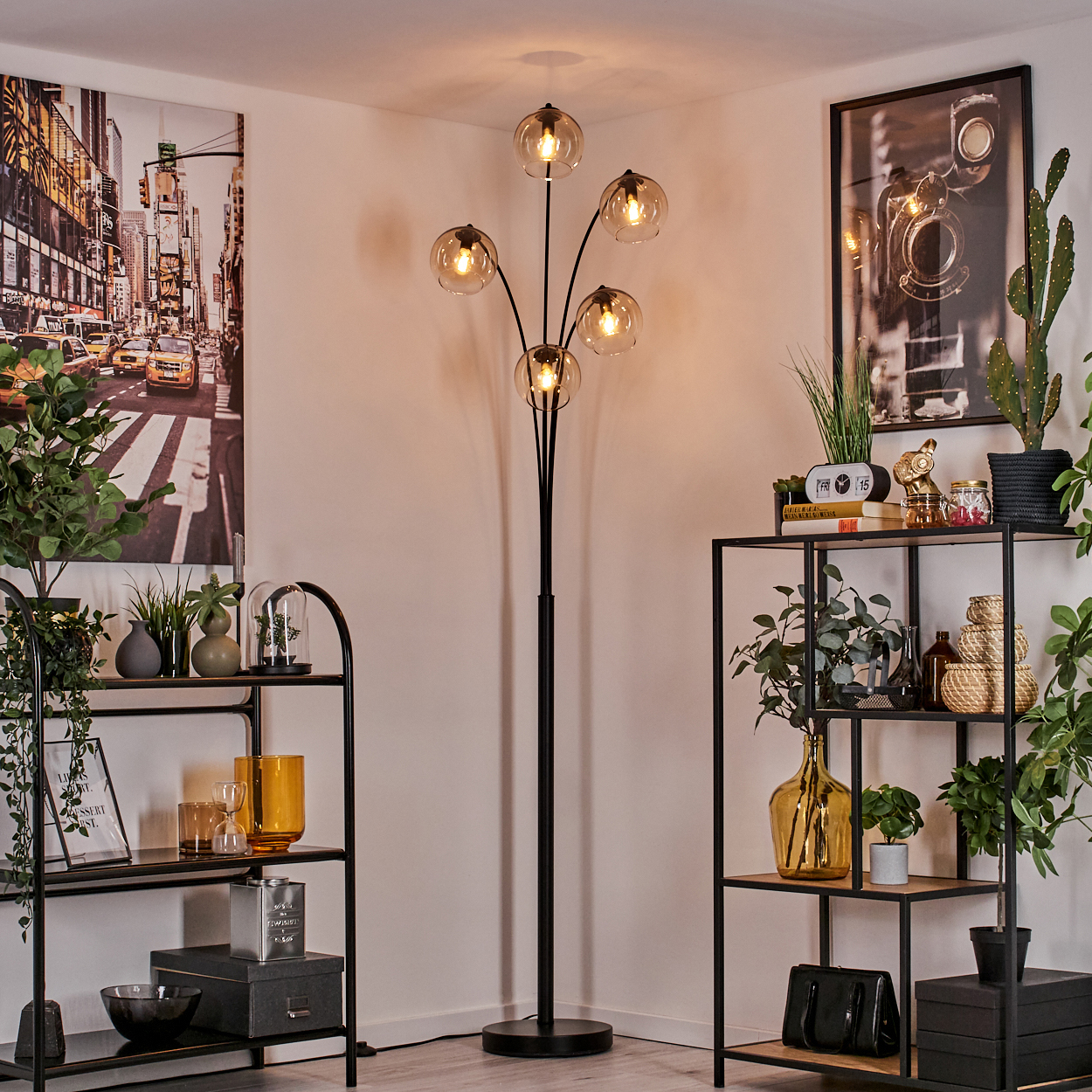 Stehlampe mit bernsteinfarbenen Glaskugeln, schwarze Regale mit Deko und New York-Kunstwerk.