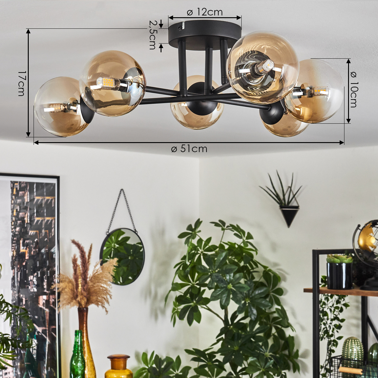 Deckenlampe mit Abmessungen. Bernsteinfarbene Glaskugeln und schwarzer Rahmen. Hintergrund: Deko und Pflanzen.