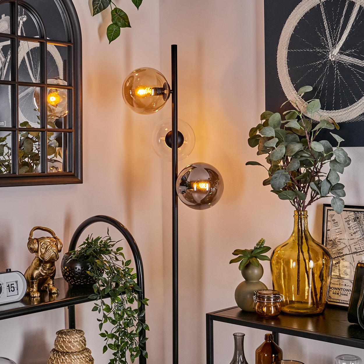 Stehlampe mit 3 Kugeln. Der Innenraum hat Dekoration und einen Spiegel. Die Lampe hat bernsteinfarbenes Licht.