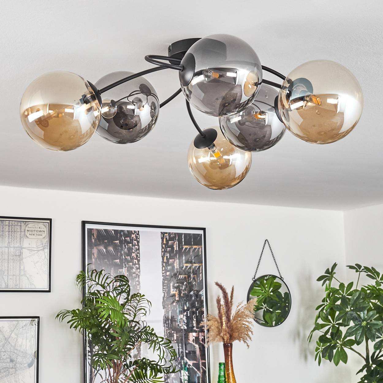 Deckenlampe mit sechs Glühbirnen. Einige sind bernsteinfarben, andere verspiegelt und andere klar. Schwarze Halterung.