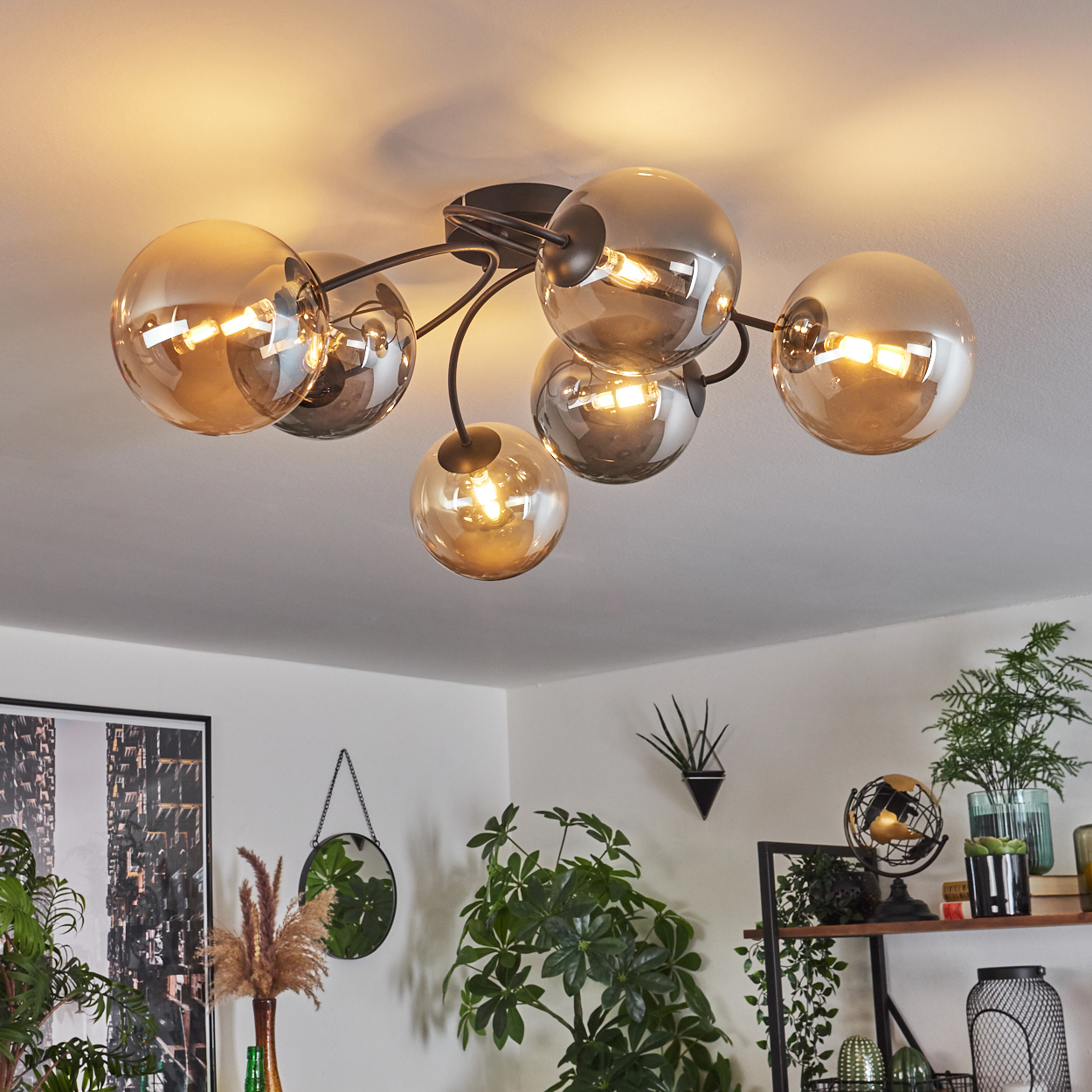 Deckenleuchte mit bernsteinfarbenen und grauen Kugeln. Weiße Decke, Innenraumhintergrund.