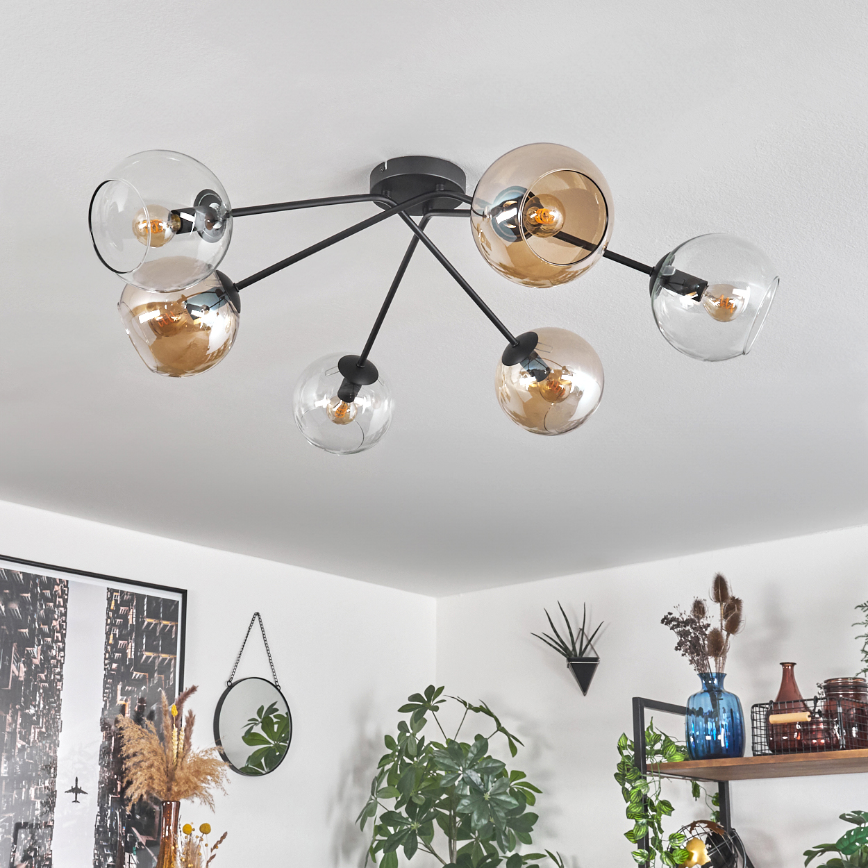 Deckenleuchte mit bernsteinfarbenen und grauen Kugeln, weiße Decke, Innenraumhintergrund.