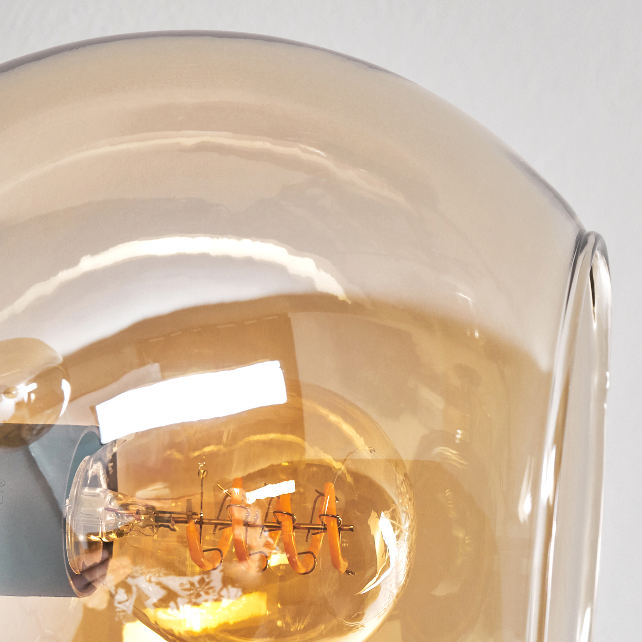Nahaufnahme einer Glühbirne in einem braunen Glasschirm.