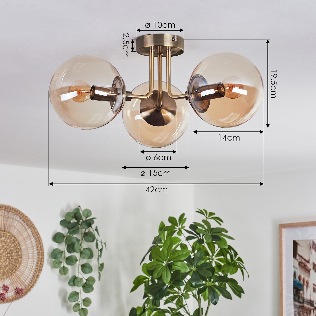 Eine Deckenlampe mit drei bernsteinfarbenen Glaskugeln, mit Abmessungen und einer Pflanze im Vordergrund.