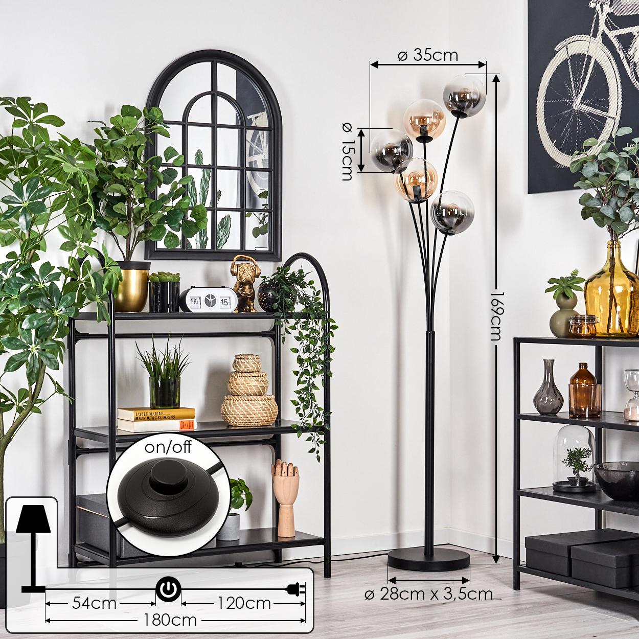 Ein Zimmer mit einer schwarzen Stehlampe, Regalen und Dekoration. Die Lampe hat Kugelschirme. Maße der Lampe werden gezeigt.