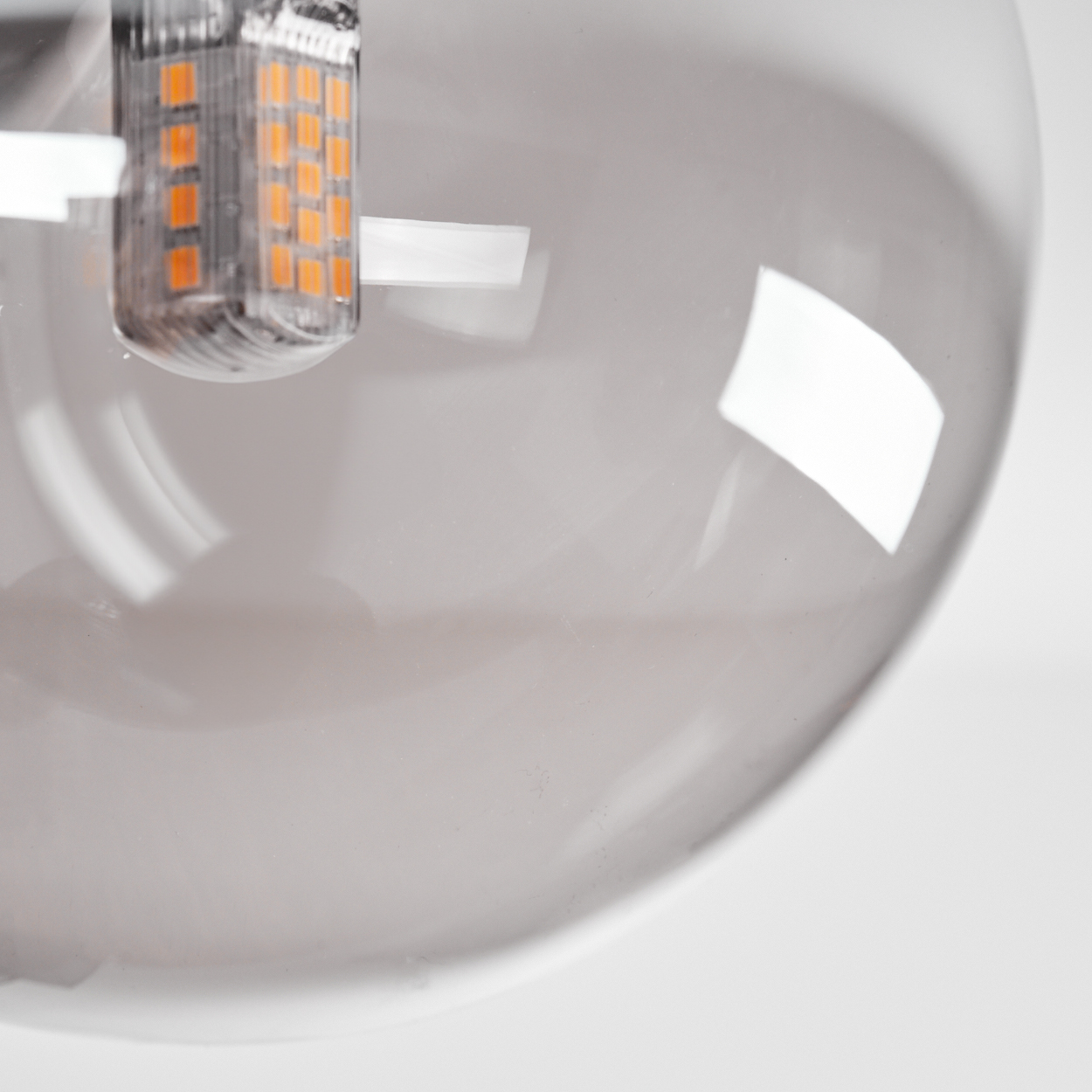 Nahaufnahme einer LED-Glühbirne in einem transparenten Globus. Weißer Hintergrund.