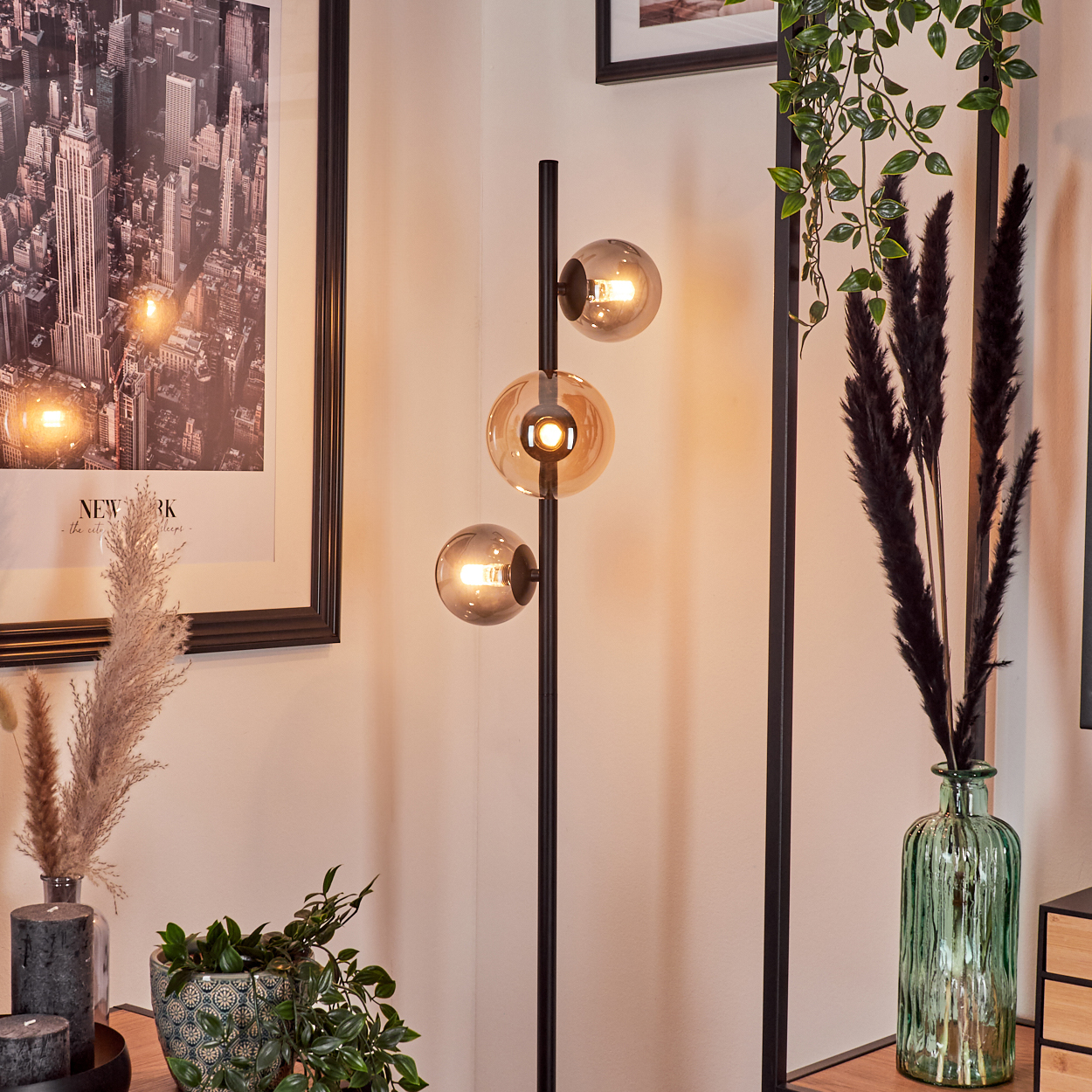 Ein modernes Wohnzimmer mit schwarzer Stehlampe und einem Stadtbild-Kunstwerk an der Wand.