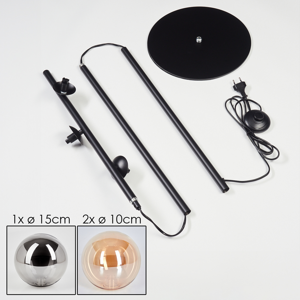 Zerlegte Teile einer schwarzen Stehlampe auf weißer Oberfläche. Enthält Basis, Stangen und zwei Glaskugeln.
